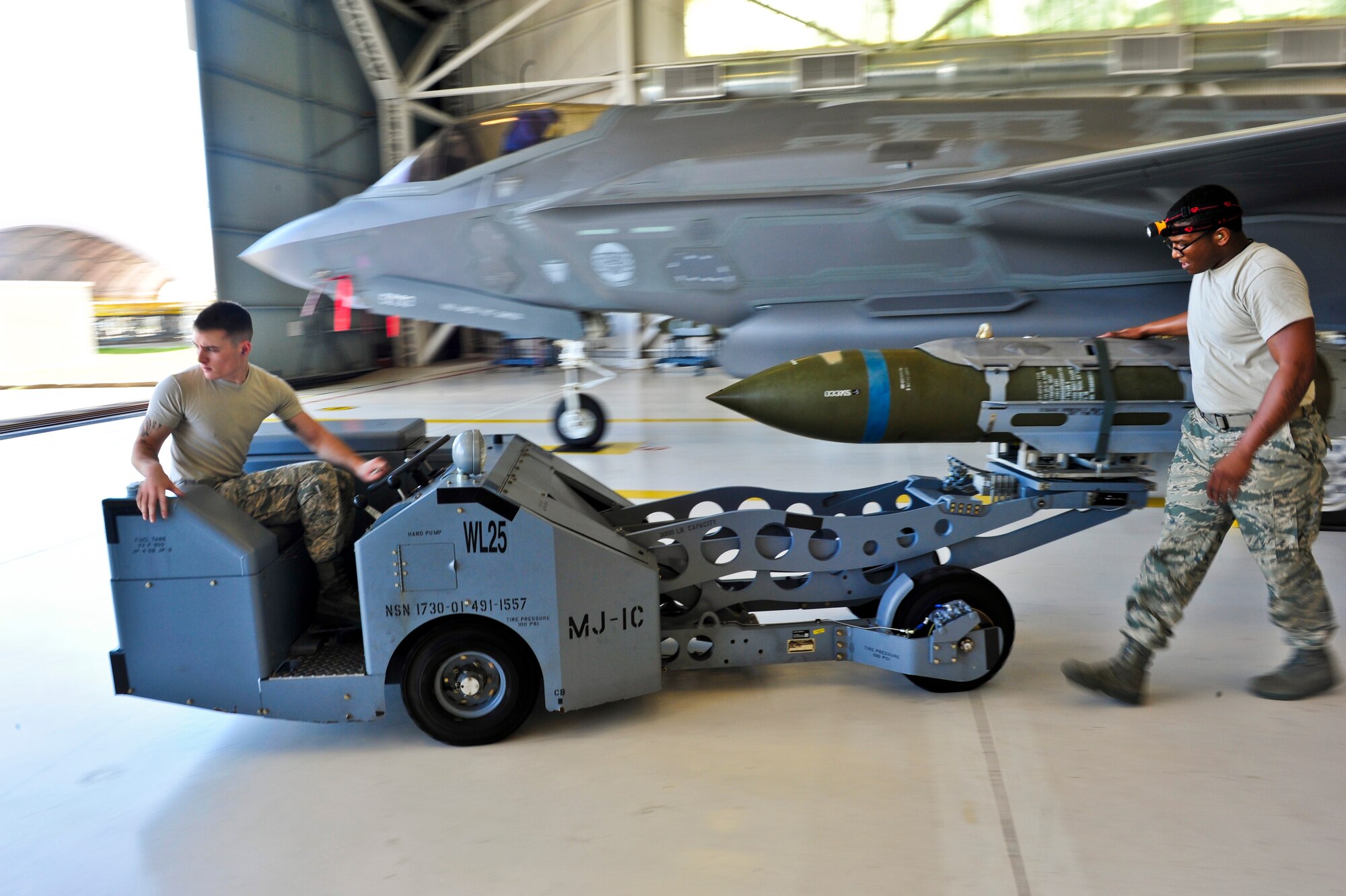 Airman 1st Class Jake Wiedmeyer, 58th Aircraft Maintenance Unit crew one load crew member, operates an MJ-1 lift truck carrying a GBU-31 Joint Direct Attack Munition as Staff Sgt. Timothy Gaulden, 58 AMU crew one load crew chief, guides him during a weapons load competition on Eglin Air Force Base, Florida, April 3, 2015.  This was the 33rd Fighter Wing’s first weapons load competition since the 2009 draw down of the F-15C Eagle mission and it determined the best F-35A Lightning II weapons load crew. During weapons load competitions, crews are evaluated on a uniform inspection, a written test, a quality assurance inspection of the teams’ tool kits and how safely, efficiently and timely they load munitions on an F-35A. (U.S. Air Force Photo/Staff Sgt. Marleah Robertson)