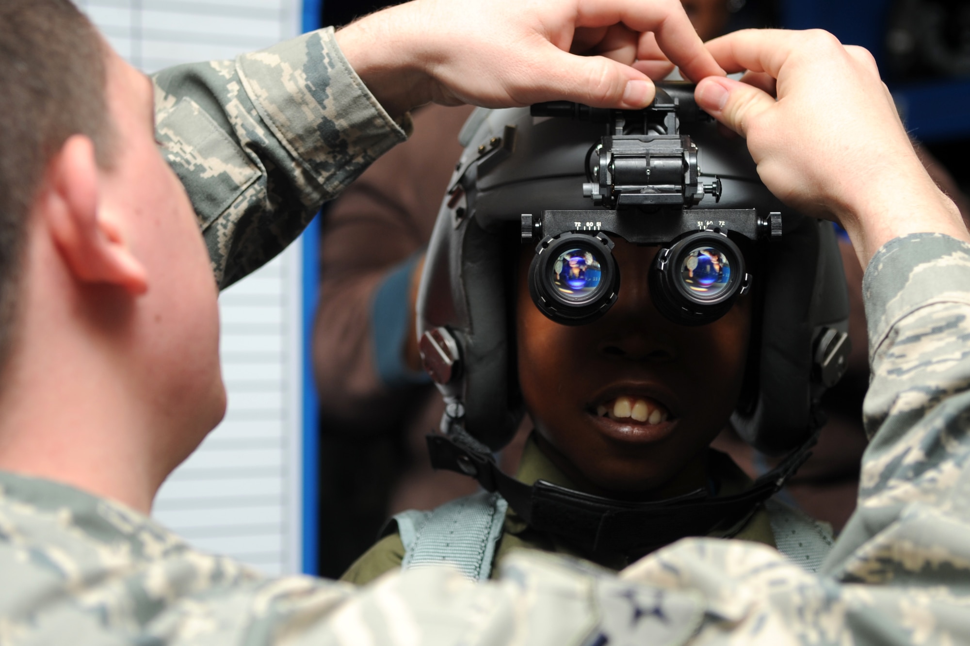Airman 1st Class Luke Locken, a 4th Operations Support Squadron aircrew flight equipment technician, adjusts night vision goggles on Jeremiah Seaberry, the 334th Fighter Squadron pilot for a day, during a 4th Fighter Wing Pilot for a Day event, April 3, 2015, at Seymour Johnson Air Force Base, N.C. Jeremiah was never expected to live past his first birthday, but has celebrated nine. (U.S. Air Force photo/Senior Airman Ashley J. Thum)