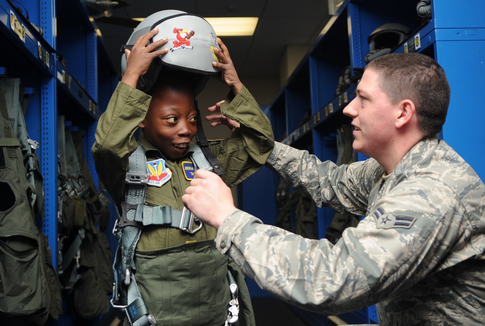 Airman 1st Class Luke Locken, a 4th Operations Support Squadron aircrew flight equipment technician, fits Jeremiah Seaberry, the 334th Fighter Squadron pilot for a day, with flight gear during a 4th Fighter Wing Pilot for a Day event, April 3, 2015, at Seymour Johnson Air Force Base, N.C. PFAD organizers chose the call sign “Swoosh” for Jeremiah as an allusion to his admiration for his favorite basketball player, Lebron James. (U.S. Air Force photo/Senior Airman Ashley J. Thum)