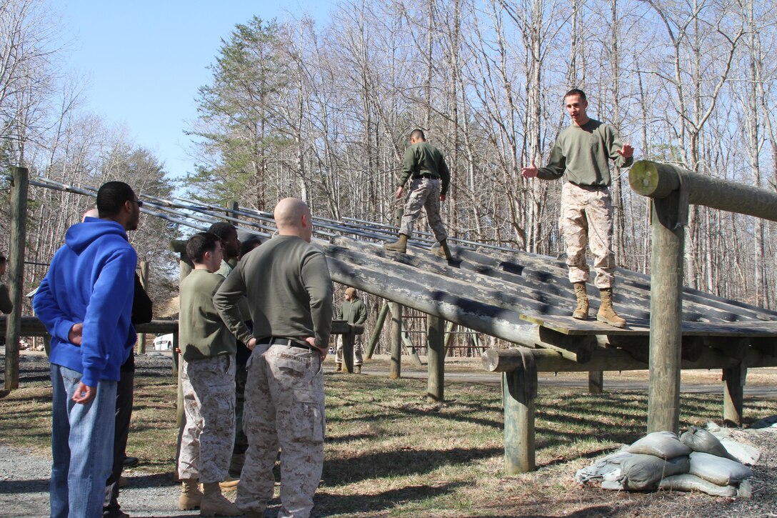 U.S. Marine Corps 2nd Lt. Joshua Foster, right, an Ashburn, Virginia, native, instructs Officer Selection Office Fairfax applicants how to navigate an obstacle course March 28, 2015, at Marine Corps Base Quantico, Virginia.  Newly commissioned officers, such as Foster, routinely work with applicants to prepare them for the rigors of Officer Candidates School. (U.S. Marine Corps photo by Sgt. Anthony J. Kirby/Released)