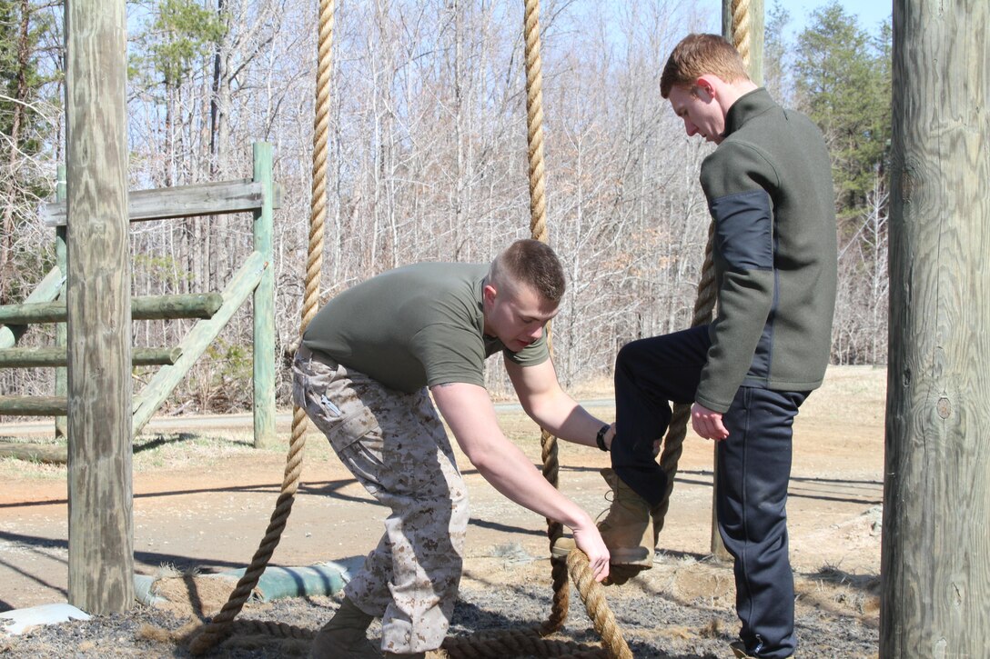 U.S. Marine Corps 2nd Lt. Phillip Allen, a Shepherdstown, West Virginia, native, assists an Officer Selection Office Fairfax applicant with proper rope-climbing technique March 28, 2015, at Marine Corps Base Quantico, Virginia.  Newly commissioned officers, such as Allen, routinely work with applicants to prepare them for the rigors of Officer Candidates School. (U.S. Marine Corps photo by Sgt. Anthony J. Kirby/Released)