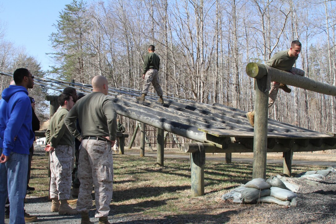 U.S. Marine Corps 2nd Lt. Joshua Foster, right, an Ashburn, Virginia, native, instructs Officer Selection Office Fairfax applicants how navigate an obstacle course March 28, 2015, at Marine Corps Base Quantico, Virginia.  Newly commissioned officers, such as Foster, routinely work with applicants to prepare them for the rigors of Officer Candidates School. (U.S. Marine Corps photo by Sgt. Anthony J. Kirby/Released)