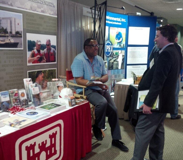 Gerald Rogers, public affairs specialist with the Norfolk District, talks about the Corps environmental mission with an attendee at the Virginia Environmental Symposium, April 1