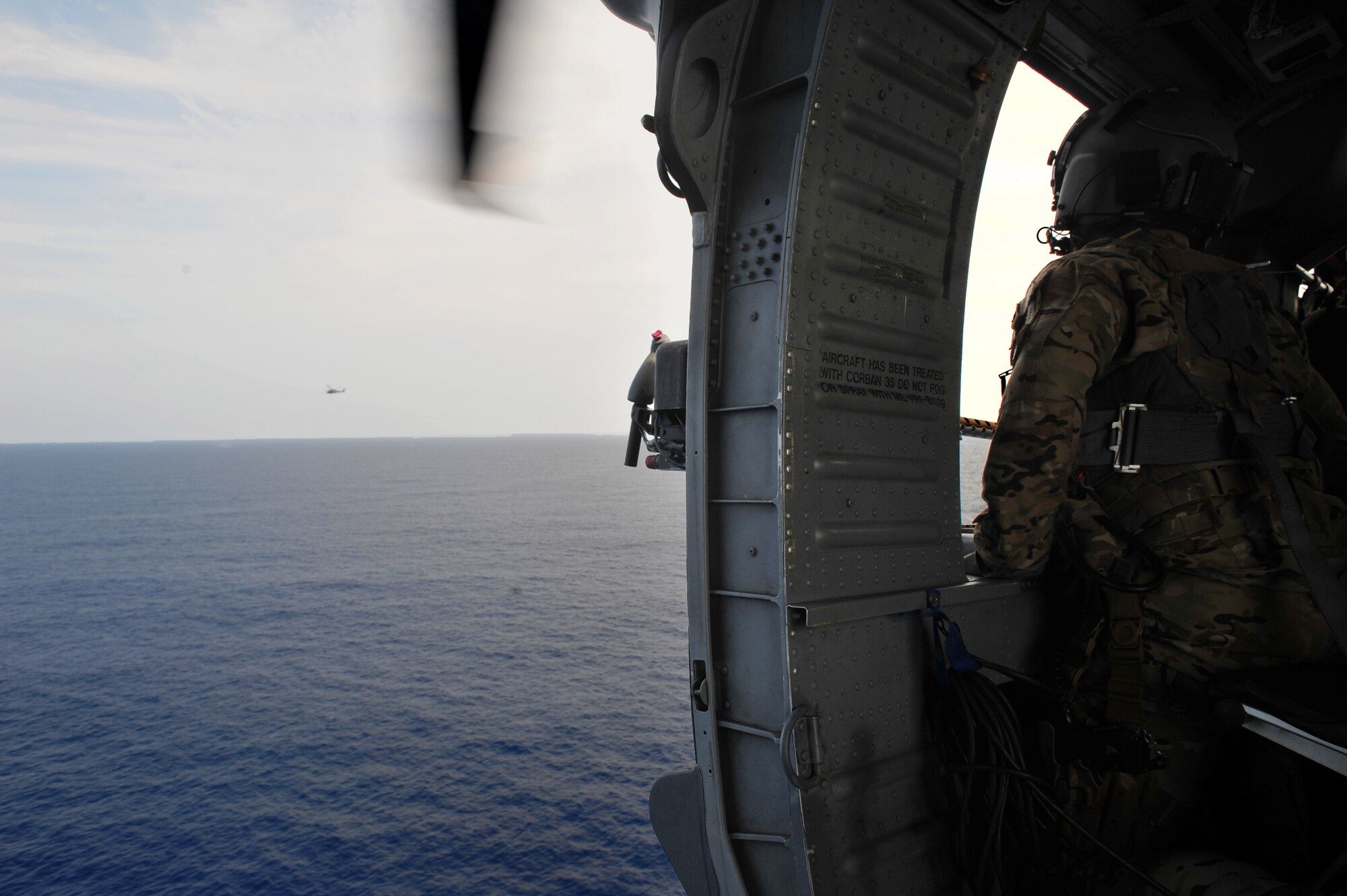 U.S. Air Force Tech. Sgt. William Warrior, 33rd Rescue Squadron special missions aviator, watches as an HH-60G Pave Hawk searches for simulated downed pilots during the Forceful Tiger Exercise, over the Pacific Ocean, April 1, 2015. The Forceful Tiger exercise was made up of 50 aircraft from Kadena Air Base, Japan, and exercised their combat capabilities. The Pave Hawk is assigned to the 33rd RQS. (U.S. Air Force photo by Staff Sgt. Rachelle Coleman)