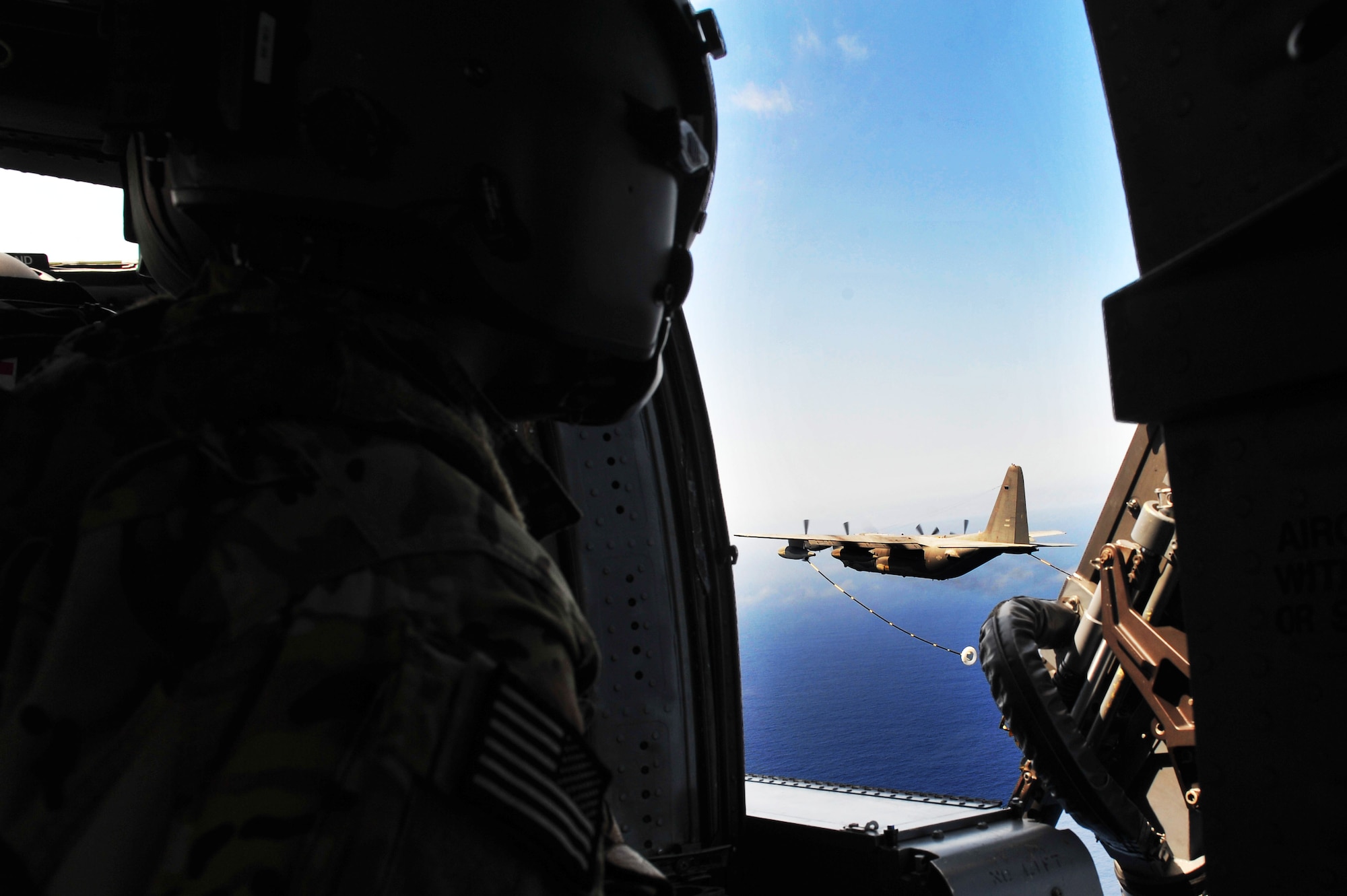 U.S. Air Force Staff Sgt. Joseph Arriza, 33rd Rescue Squadron special missions aviator, watches an MC-130P Combat Shadow approach to refuel two HH-60G Pave Hawk helicopters over the Pacific Ocean, April 1, 2015. The Pave Hawks and Combat Shadow were part of Forceful Tiger, a large-force exercise to demonstrate the 18th Wing’s combat capabilities. The Combat Shadow is assigned to the 17th Special Operations Squadron and the Pave Hawks are assigned to the 33rd RQS. (U.S. Air Force photo by Staff Sgt. Rachelle Coleman)