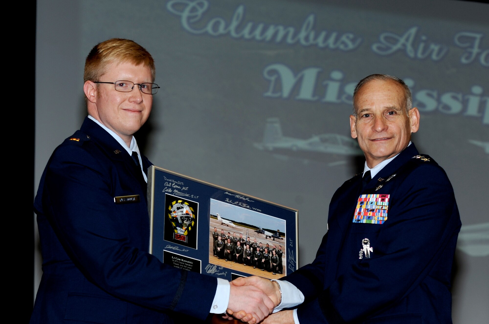 2nd Lt. Nicholas McFadden, class leader of Specialized Undergraduate Pilot Training Class 15-07, hands a shadowbox to Lt. Gen. James Kowalski, Deputy Commander, U.S. Strategic Command Offutt Air Force Base, Oklahoma, at Class 15-07’s graduation ceremony on Columbus Air Force Base, Mississippi, April 3, 2015. The shadowbox contains class 15-07’s group picture with signatures from the graduates and their class patch. (U.S. Air Force photo/Elizabeth Owens)