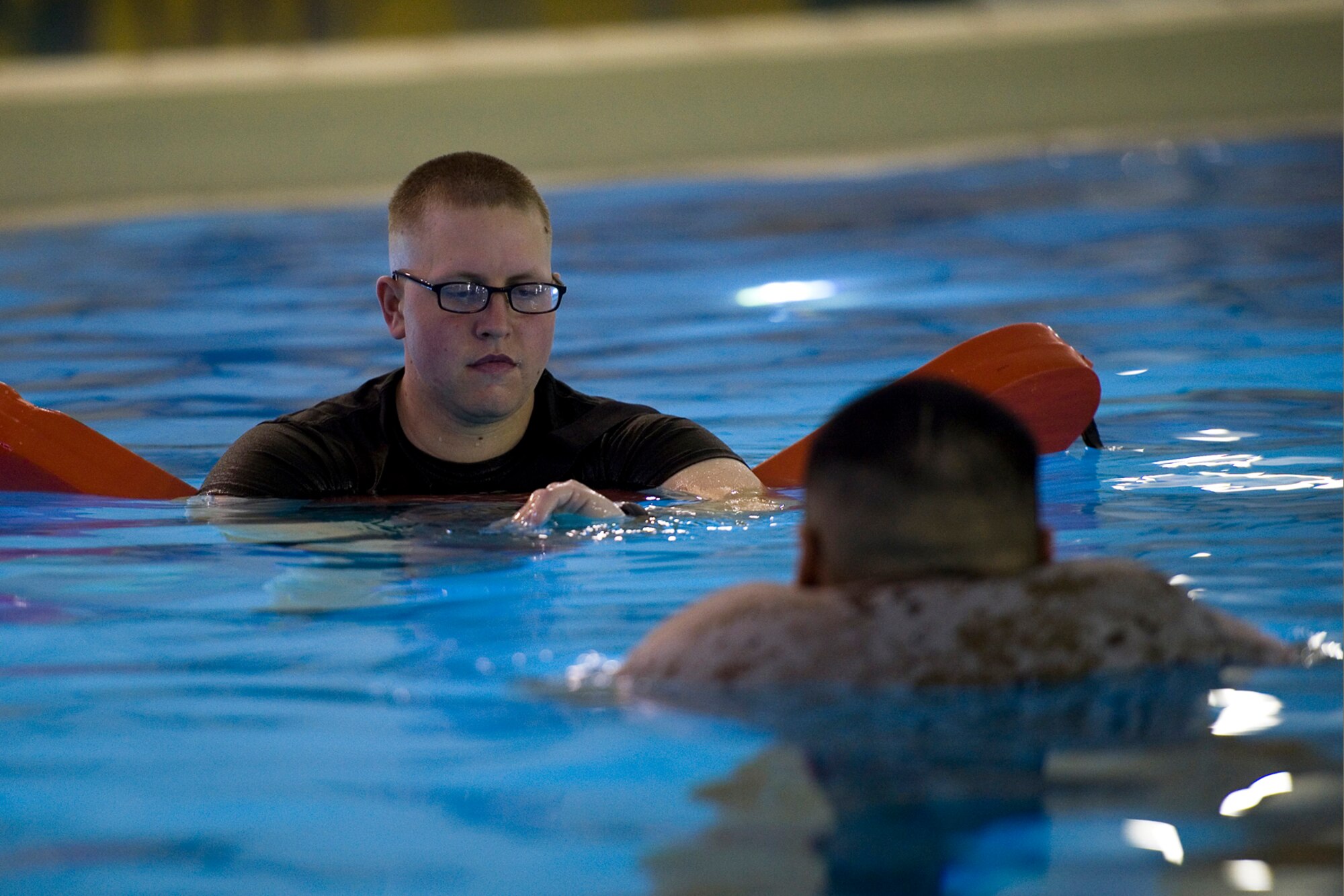 U.S. Marine Corps Sgt. Dustin O'hair, Engineer Service Company, Combat Logistics Battalion, 4th Marine Logistics Group instructor of water survival, checks his stop-watch as U.S. Marine Corps Sgt. Alonso Guajardo, Detachment 1, Communication Company, Combat Logistics Regiment 45, 4th Marine Logistics Group wireman, treads water with assistance of his inflated blouse during the Marine Corps water survival training program basic level qualification at Great Lakes Naval Station, Ill., March 21, 2015. Blouse inflation is a flotation technique taught during the course to help Marines float in the event of a water-borne mishap. (U.S. Air Force photo/Tech. Sgt. Benjamin Mota)