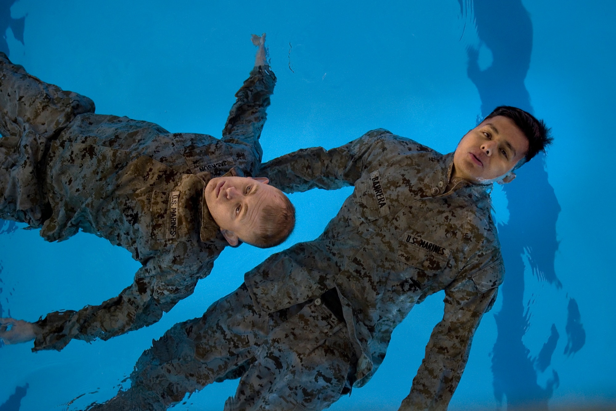 U.S. Marine Corps Cpl. Kevin Jackson, Detachment 1, Communication Company, Combat Logistics Regiment 45, 4th Marine Logistics Group wireman, and U.S. Marine Corps Cpl. Luis Barrera, Detachment 1 radio operator, float to remain above water during their Marine Corps water survival training program basic level qualification at Great Lakes Naval Station, Ill., March 21, 2015. During basic level qualifications, Marines have to remove their flak jackets, helmets and rifles in shallow water in less than 10 seconds, enter water from a 15-foot tower simulating an 'abandon ship' technique, tread water for four minutes, and conduct a 25-meter pack-swim. (U.S. Air Force photo/Tech. Sgt. Benjamin Mota)