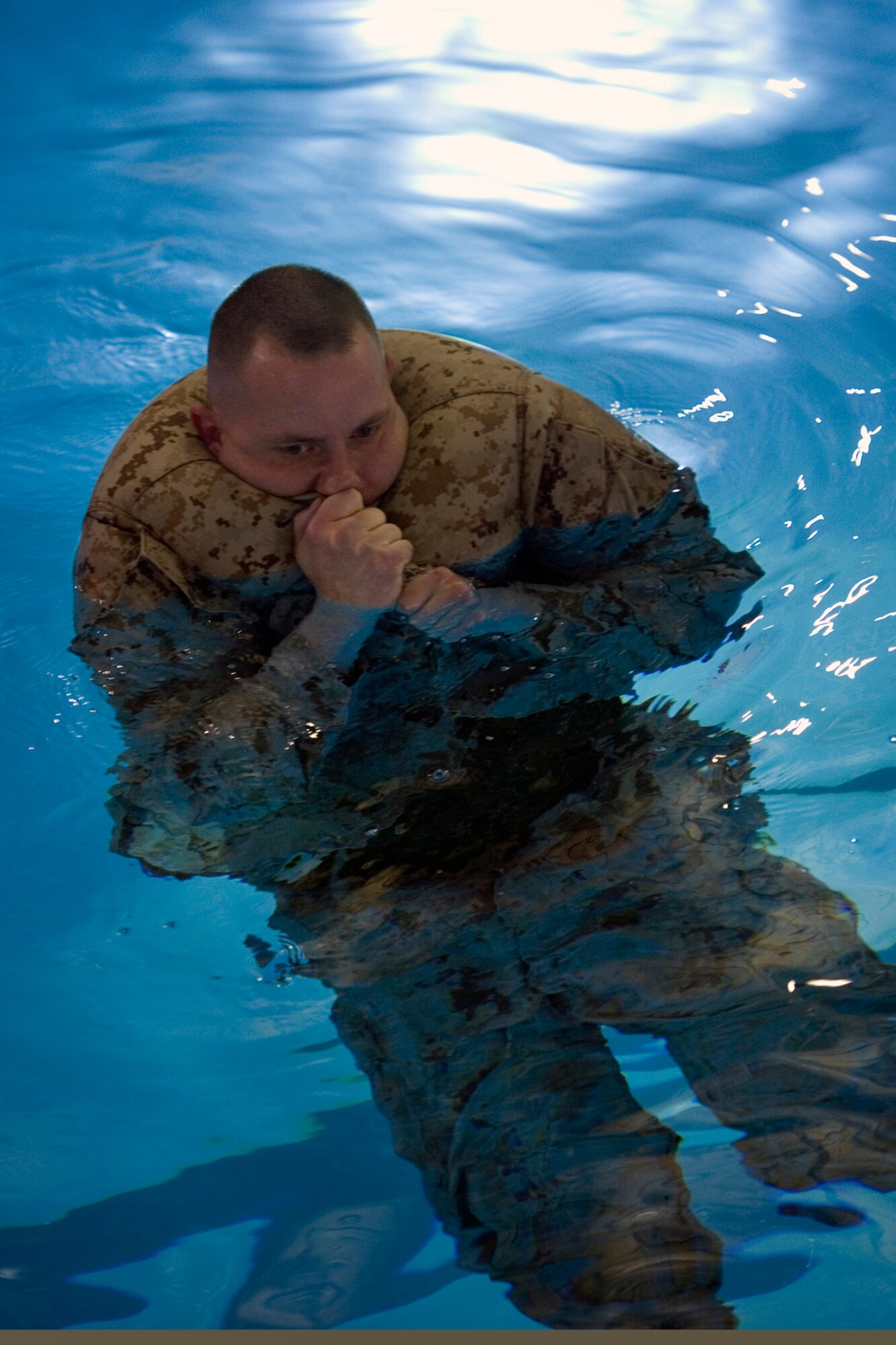 U.S. Marine Corps Staff Sgt. Cody Andrews, Detachment 1, Communication Company, Combat Logistics Regiment 45, 4th Marine Logistics Group motor transport chief, inflates his blouse to help tread water during the Marine Corps water survival training program basic level qualification at Great Lakes Naval Station, Ill., March 21, 2015.  Blouse inflation is a flotation technique taught during the course to help Marines float in the event of a water-borne mishap. (U.S. Air Force photo/Tech. Sgt. Benjamin Mota)