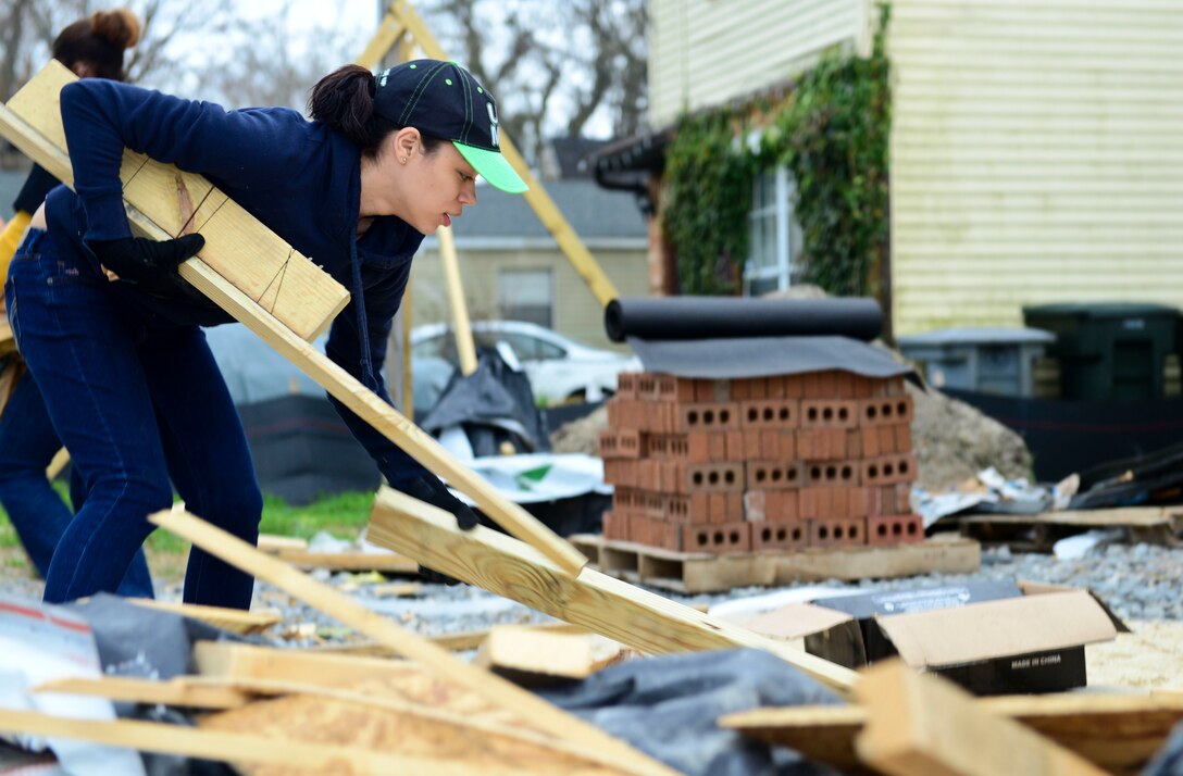 U.S. Army Spc. Yamira Labraor-Rosario, 99th Transportation Detachment Movement Control Team, 53rd Movement Control Battalion, 7th Transportation Brigade (Expeditionary) movement specialist, picks up scrap wood, in Hampton, Va., April 4, 2015. Labraor-Rosario cleaned up houses while volunteering for the Habitat for Humanity Peninsula and Greater Williamsburg Habitat for Heroes program.  (U.S. Air Force Photo by Senior Airman Kimberly Nagle/Released)