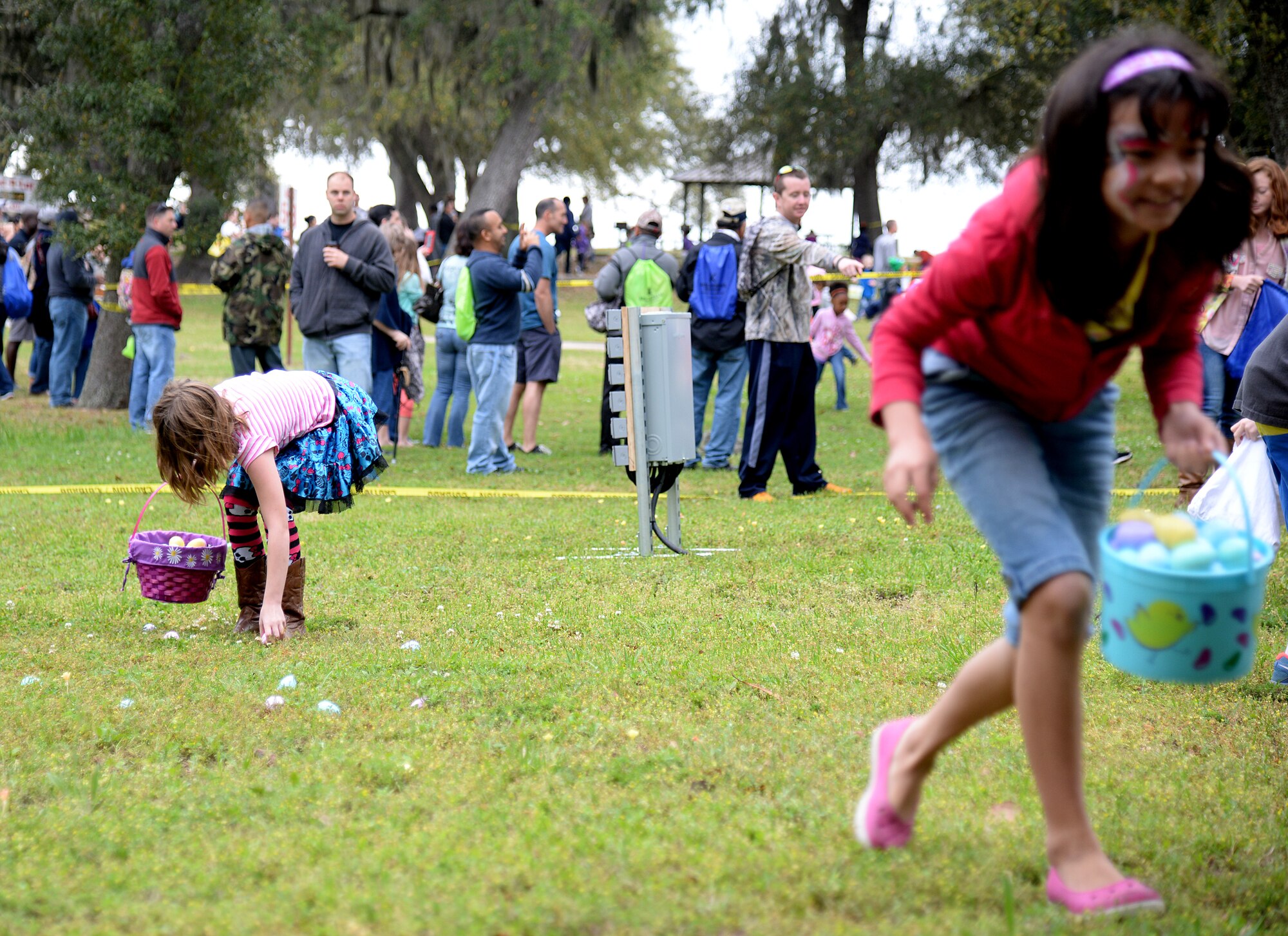 Children participate in an Easter egg hunt at the 2015 Child Pride Day, April 4, 2015, at marina park, Keesler Air Force Base, Miss. More than 600 children and parents from Keesler attended the event that featured activities, demonstrations and attendees with information on programs focused on care of military families. (U.S. Air Force photo by Senior Airman Holly Mansfield)