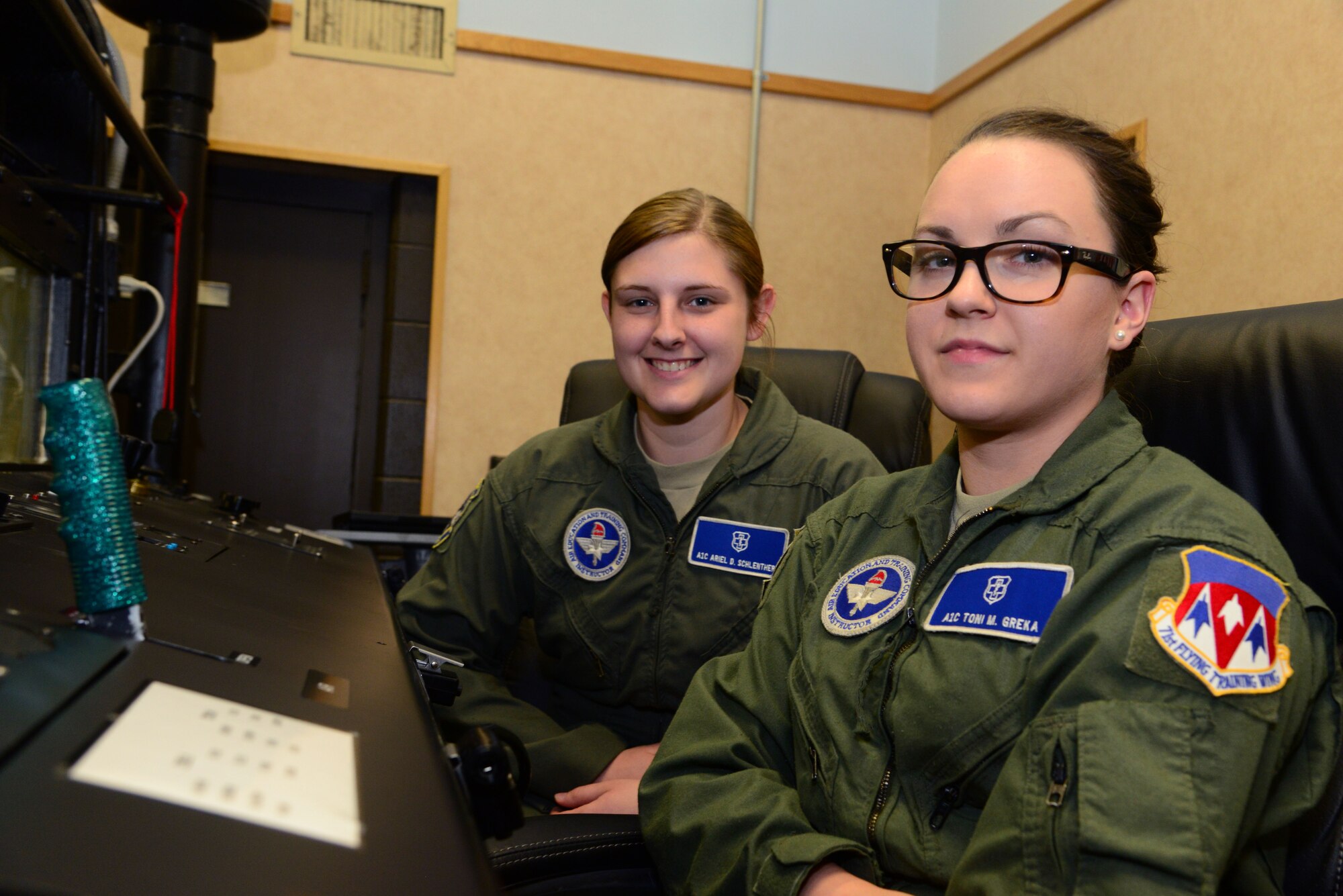 VANCE AIR FORCE BASE, Okla. -- Airmen 1st Class Toni Greka, front, and Ariel Schlenther, rear, both 71st Medical Operations Group aerospace physiology technicians, sit at the controls of a hypobaric chamber here. Greka and Schlenther were selected for below-the-zone promotion to senior airman March 19. (U.S. Air Force photo/Senior Airman Frank Casciotta)