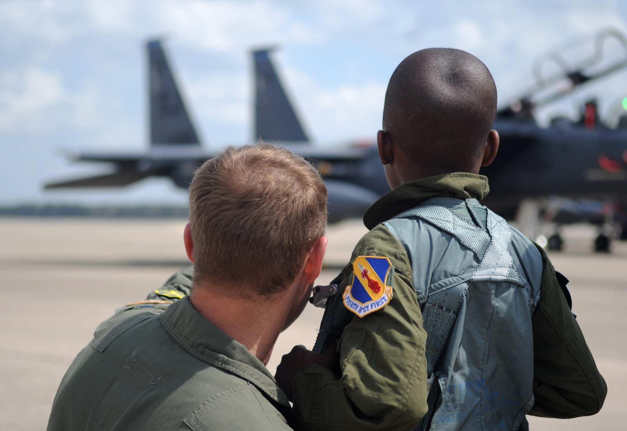 Capt. Adam Luber, 334th Fighter Squadron pilot, and Jeremiah Seaberry, 334th FS pilot for a day, watch F-15E Strike Eagles on the flightline during a 4th Fighter Wing Pilot for a Day event, April 3, 2015, at Seymour Johnson Air Force Base, North Carolina. Jeremiah described Luber as “awesome.” (U.S. Air Force photo/Senior Airman Ashley J. Thum)