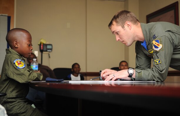 Capt. Adam Luber, 334th Fighter Squadron pilot, briefs Jeremiah Seaberry, 334th FS pilot for a day, on their “mission” during a 4th Fighter Wing Pilot for a Day event, April 3, 2015, at Seymour Johnson Air Force Base, North Carolina. Luber explained the “Top Secret” mission to his crewmate before they headed outside to their jet. (U.S. Air Force photo/Senior Airman Ashley J. Thum)