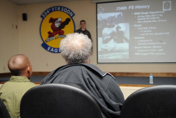 Jeremiah Seaberry, 334th Fighter Squadron pilot for a day, and his grandmother, Portia Seaberry, listen to a mission brief from Capt. Kat Frost, Pilot for a Day project officer, during a 4th Fighter Wing PFAD event, April 3, 2015, at Seymour Johnson Air Force Base, North Carolina. The PFAD program allows children who suffer from a chronic illness or disability to experience a day in the life of a fighter pilot. (U.S. Air Force photo/Senior Airman Ashley J. Thum)