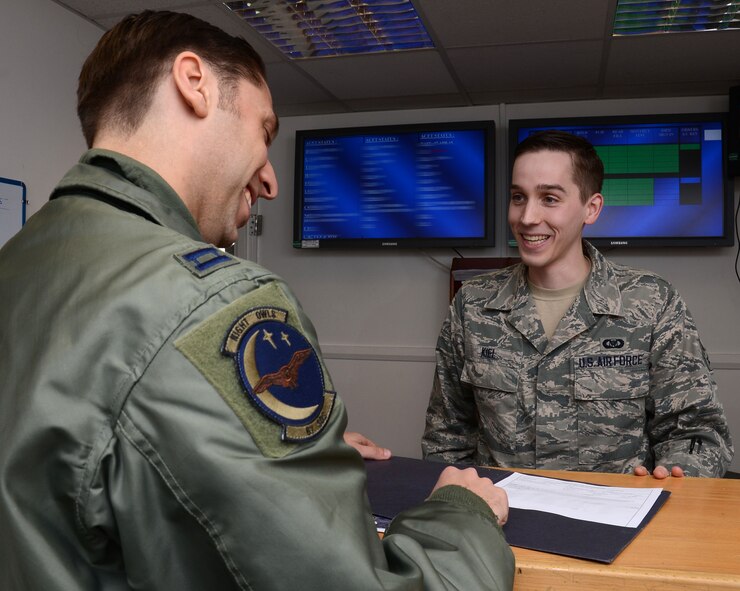 U.S. Air Force Senior Airman Nicholas Kiel, right, 67th Special Operations Squadron avation ressource management journeyman from Muskegon, Mich., shows U.S. Air Force Capt. Justin Mastrangelo, 67th SOS MC-130 J instructor pilot from Sumter, S.C., his flight orders for the next day’s flight April 7, 2015, on RAF Mildenhall, England. (U.S. Air Force photo illustration by Gina Randall/Released) 