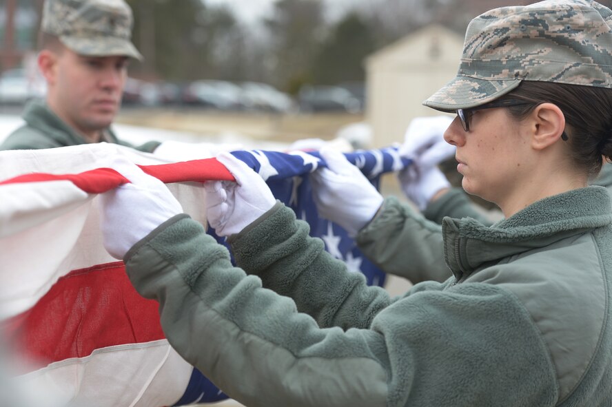 Second Lt. Lauren Bisacky, Patriot Honor Guard member, folds the American flag as part of a six-person detail during a funeral honors training exercise, Apr. 2. The Patriot Honor Guard is comprised of active duty Airmen, Air National Guard and Air Force Reserve from the six New England states and New York State. (U.S. Air Force photo by Jerry Saslav)