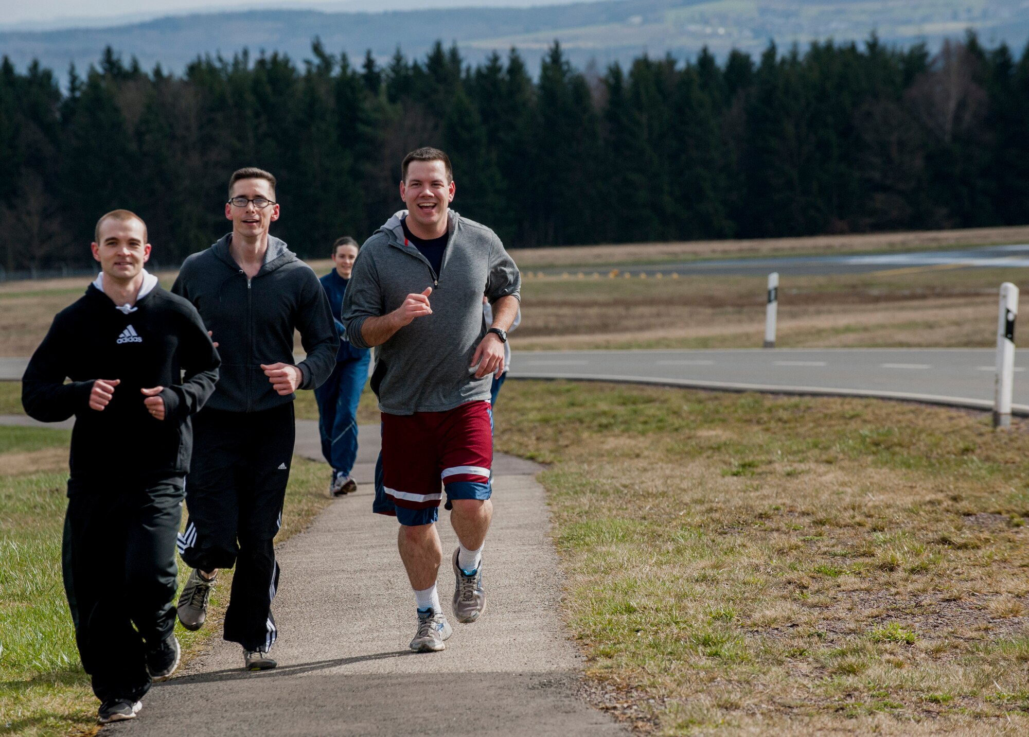 U.S. Air Force Staff Sgt. Robert Gangwish, communications focal point supervisor, left, U.S. Air Force Staff Sgt. Aaron Campbell, project manager, middle, and U.S. Air Force Jonathon Riley, client systems technician, right, all from the 52nd Communications Squadron, run during the Sexual Assault Awareness and Prevention Month 5K CLEAR Challenge Run at Spangdahlem Air Base, Germany, April 2, 2015. The run served as one of the many events of SAAPM, a month designated for April with the goal of raising sexual assault awareness, and featured the acronym representing Courage, Leadership, Education, Advocacy and Respect. A total of 50 people participated in the run, with 20 volunteers and five teams of runners. (U.S. Air Force photo by Airman 1st Class Timothy Kim/Released)