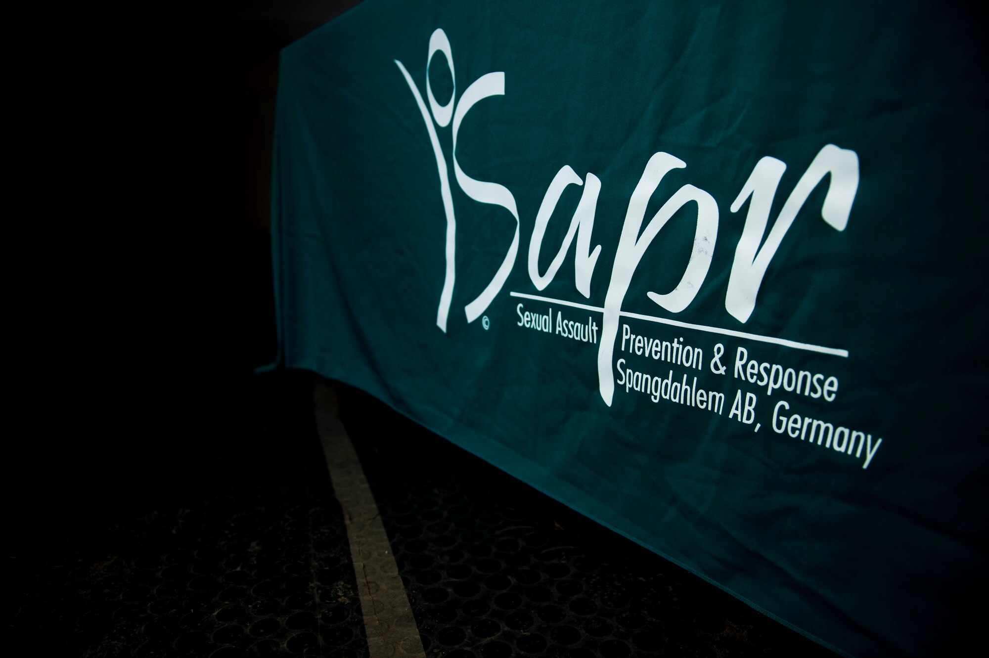 The Sexual Assault Prevention & Response logo is displayed on a table cloth during the Sexual Assault Awareness and Prevention Month 5K CLEAR Challenge Run at Spangdahlem Air Base, Germany, April 2, 2015. The run served as one of the many events of SAAPM, a month designated for April with the goal of raising sexual assault awareness, and featured the acronym representing Courage, Leadership, Education, Advocacy and Respect. The Sexual Assault Prevention and Response office coordinated the events for SAAPM and sponsored the 5K challenge run. (U.S. Air Force photo by Airman 1st Class Timothy Kim/Released)