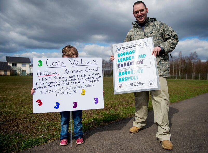 Volunteers hold up signs that detail various challenges participants must perform during the Sexual Assault Awareness and Prevention Month 5K CLEAR Challenge Run at Spangdahlem Air Base, Germany, April 2, 2015. The run served as one of the many events of SAAPM, a month designated for April with the goal of raising sexual assault awareness, and featured the acronym representing Courage, Leadership, Education, Advocacy and Respect. The 5K run had five “challenge” stations, manned by volunteers who are victim advocate members, which identified a trait to SAAPM and listed a challenge participants must accomplish before moving on to the next station. (U.S. Air Force photo by Airman 1st Class Timothy Kim/Released)