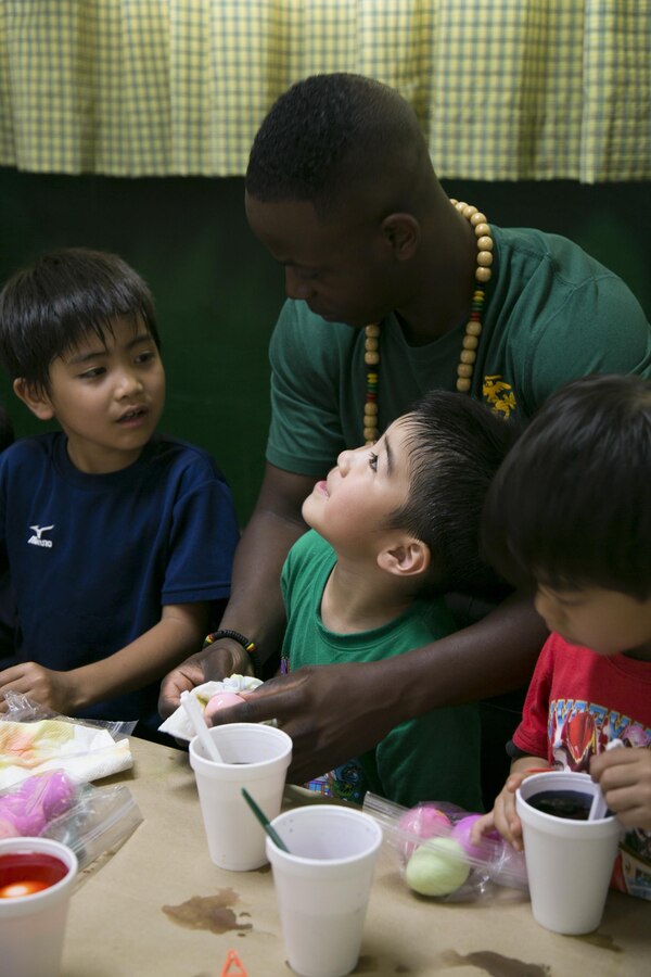 Gunnery Sgt. Maurice Williams teaches children how to dye eggs April 4 during a United Service Organization Easter celebration on Camp Schwab, Okinawa, Japan. The camp opened its gates to Henoko and Nago City residents to introduce them to Easter traditions that children in the U.S. participate in during the holiday. The Marines spent the day guiding the children through different Easter activities, such as egg dyeing, making rabbit masks and an egg hunt. Williams is a native of Killeen, Texas, and the operations chief with 3rd Marine Division, III Marine Expeditionary Force. 