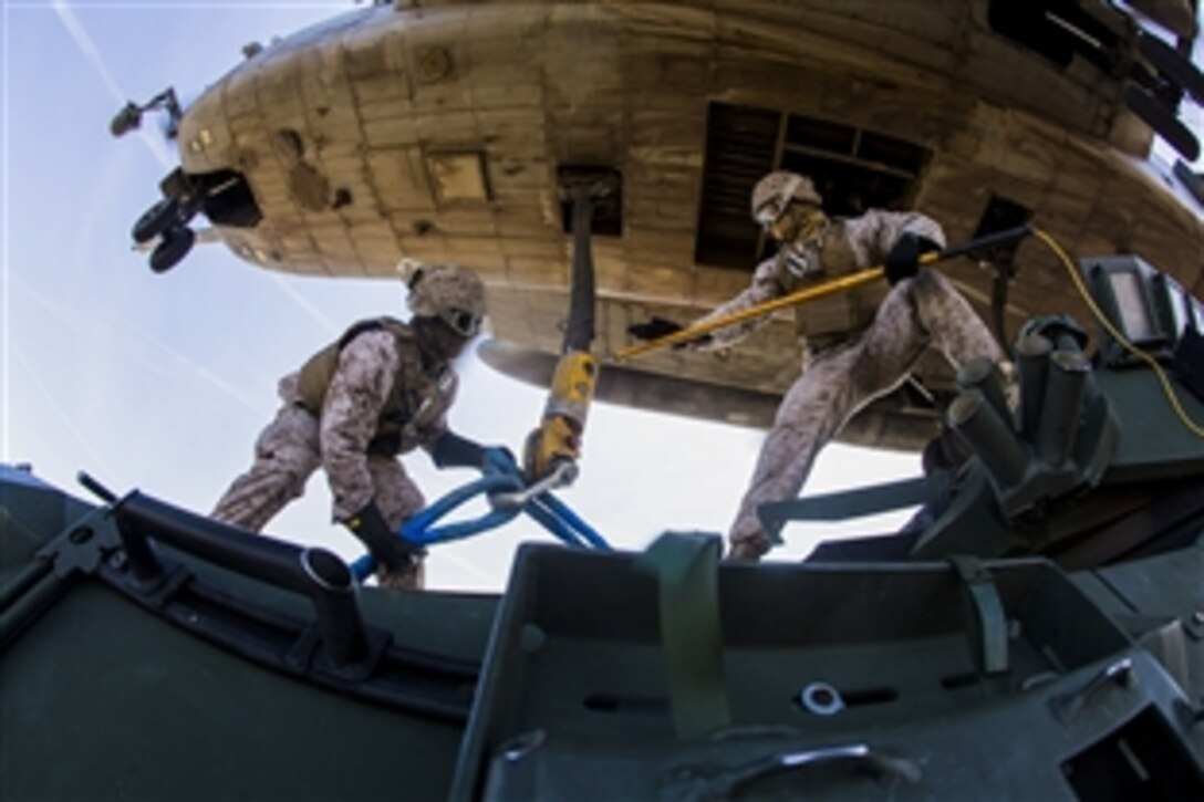Marine Corps Sgt. Anthony B. Lawrence, left, and Cpl. Matthew T. Robinson conduct an external lift with Marine Heavy Helicopter Squadron 361 during Weapons and Tactics Instructor Course 2-15 near Yuma, Ariz., April 3, 2015. Lawrence and Robinson are assigned to Landing Support Company, 1st Transportation Support Battalion.