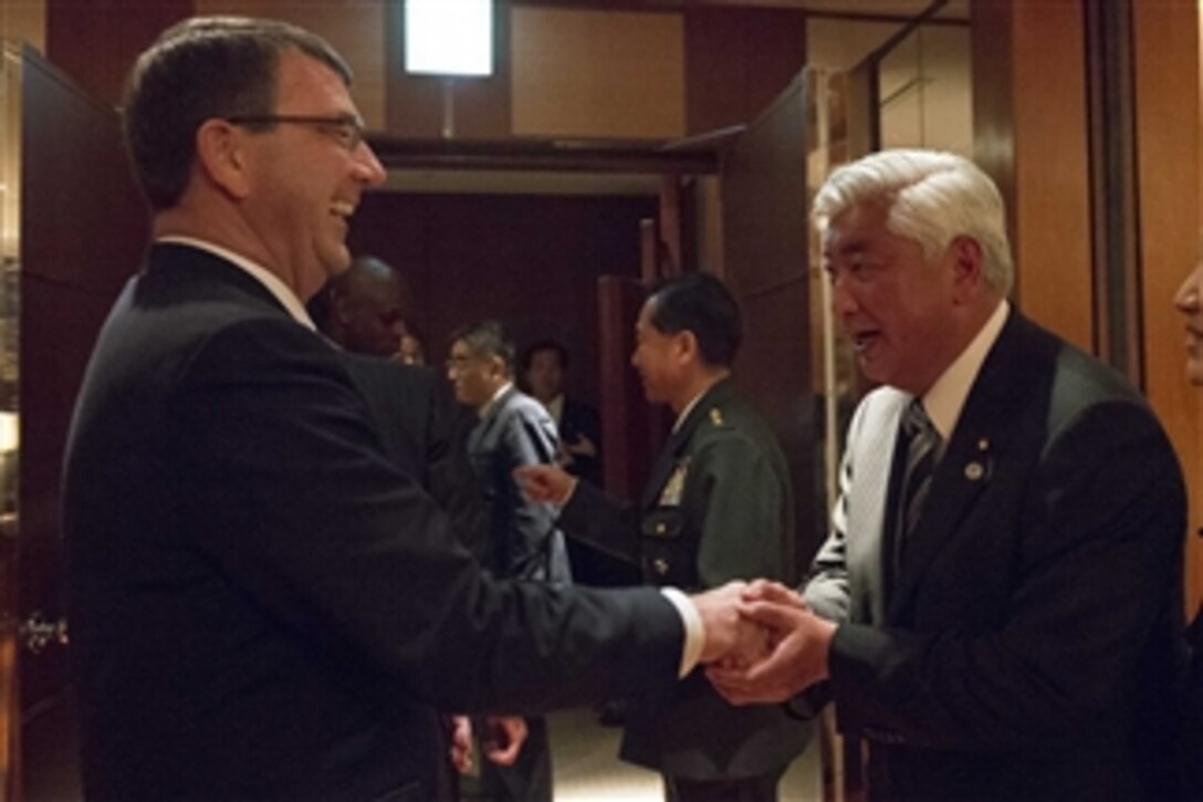 Defense Secretary Ash Carter gives a challenge coin to Japanese Defense Minister Gen Nakatani after a dinner hosted by Nakatani at the Park Hyatt Hotel in Tokyo, April 8, 2015. Carter is on a visit to the U.S. Pacific Command Area of Responsibility to make observations for the future force and the rebalance to the Pacific.