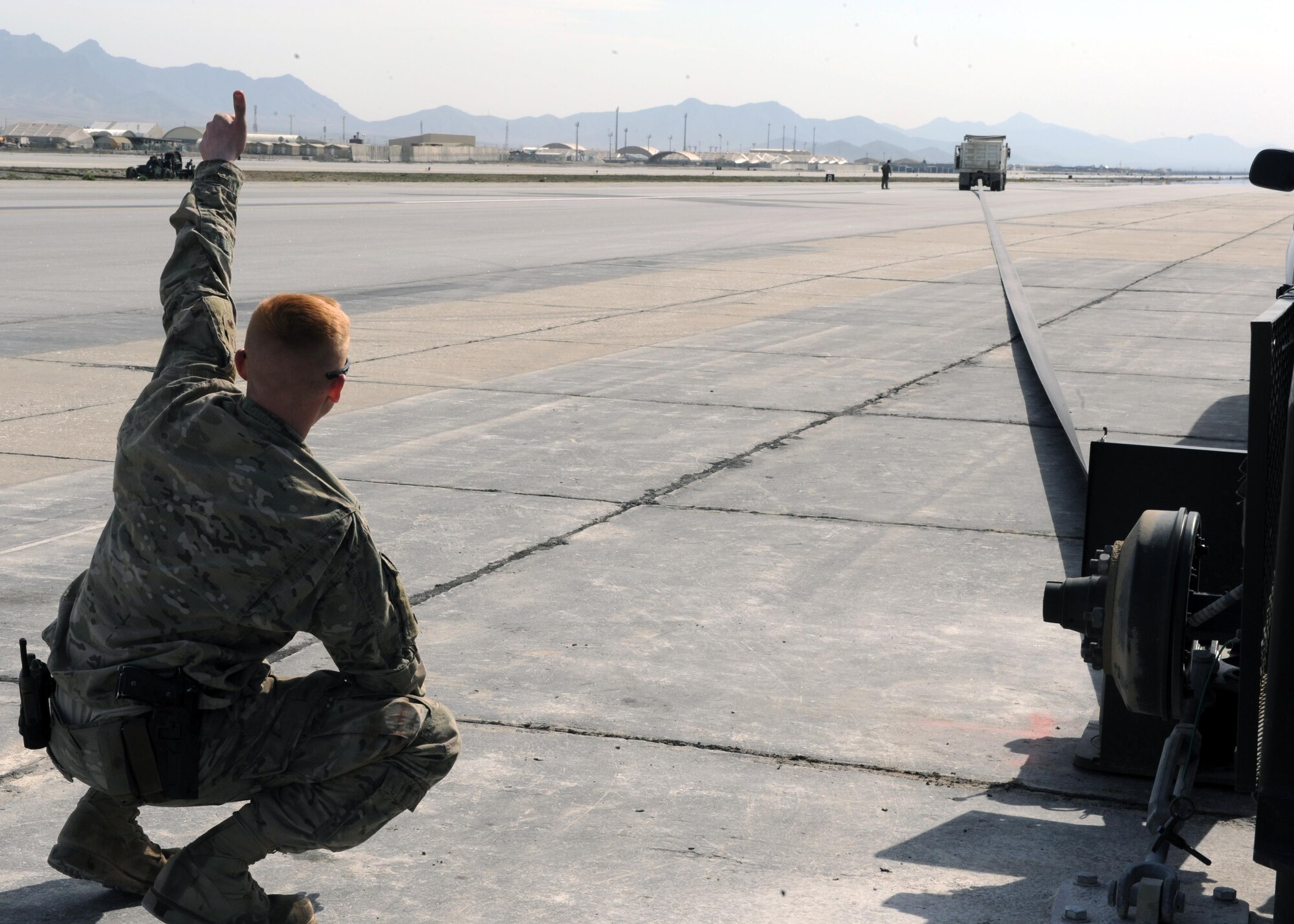 U.S. Air Force Senior Airman Bodin Rasbeck, 455th Expeditionary Civil Engineer Squadron power production journeyman, gives the thumbs up to indicate a successful test of a Mobile Aircraft Arresting System March 18, 2015 at Bagram Airfield, Afghanistan. The MAAS was from a separate taxiway as part of the construction of an alternate runway at Bagram. (U.S. Air Force photo by Staff Sgt. Whitney Amstutz/released)