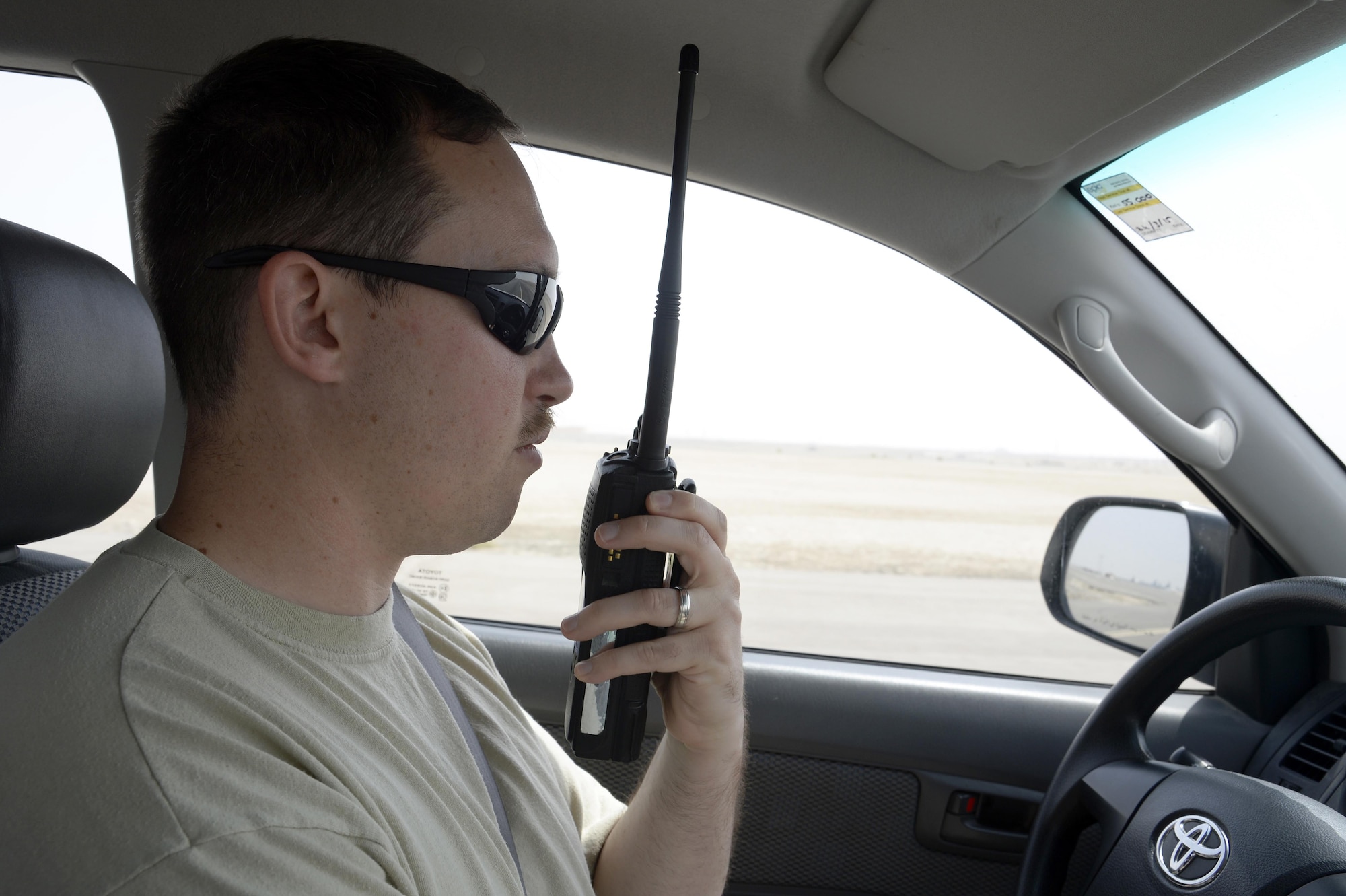 Senior Airman Matthew, airfield management shift lead, radios into the tower for approval to access an active runway during a routine inspection at an undisclosed location in Southwest Asia April 1, 2015. Airfield Management inspects the runway and taxiways throughout the day to make sure there is no debris that can damage aircraft. Matthew is currently deployed from McChord Air Force Base, Wash. (U.S. Air Force photo/Tech. Sgt. Marie Brown/RELEASED)