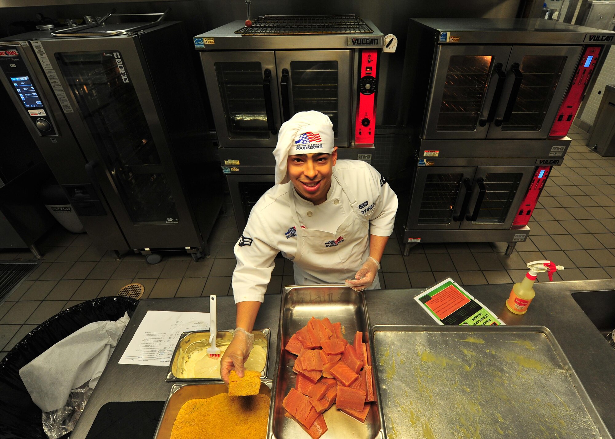 Airman 1st Class Jonathan Martinez, 1st Special Operations Force Support Squadron food services journeyman, prepares breaded salmon, April 8, 2015, at Hurlburt Field, Fla. Martinez was awarded the 2014 Hennessy Award for individual excellence in the food services career field. (U.S. Air Force photo by Airman 1st Class Ryan Conroy/Released)