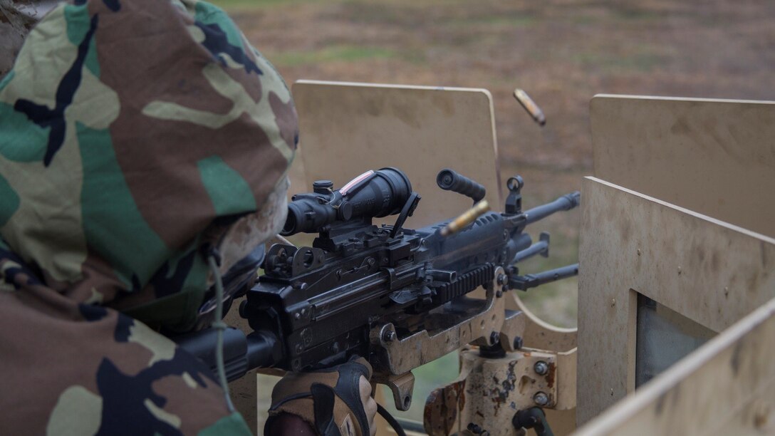 A Marine with 2nd Combat Engineer Battalion shoots the M249 Squad Automatic Weapon after donning and clearing his gas mask at range SR-7 aboard Camp Lejeune, N.C., April 7, 2015. Approximately 30 Marines from the battalion conducted a two-day, machine-gun range in which they shot the M249 Squad Automatic Weapon, M240 Bravo medium machine gun and M2 .50-caliber heavy machine gun from both the mounted and un-mounted positions at targets placed at unknown distances.