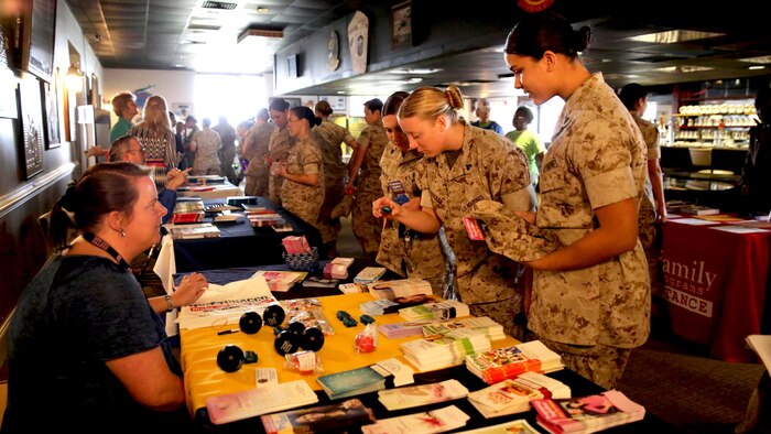 Female Marines look at brochures of information during the education fair at the fourth annual Vivian A. Holmes Female Marine Symposium at Marine Corps Air Station New River, North Carolina, March 26, 2015. During the symposium, female Marines received informational classes, participated in guided discussions and attended an education-station fair to get information on resources directly related to female Marines and their families.