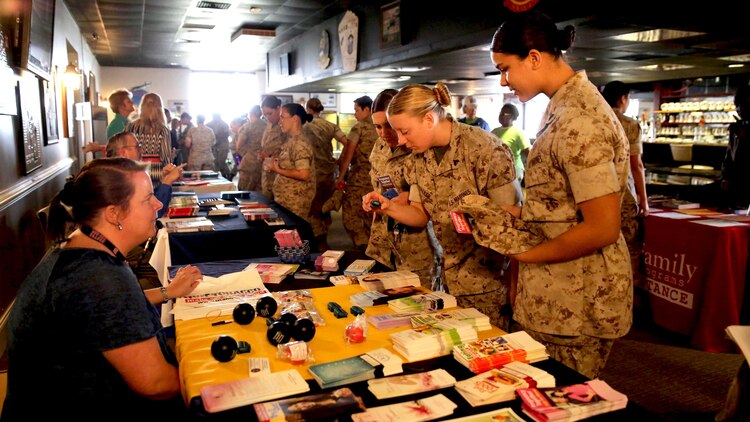 Female Marines look at brochures of information during the education fair at the fourth annual Vivian A. Holmes Female Marine Symposium at Marine Corps Air Station New River, North Carolina, March 26, 2015. During the symposium, female Marines received informational classes, participated in guided discussions and attended an education-station fair to get information on resources directly related to female Marines and their families.