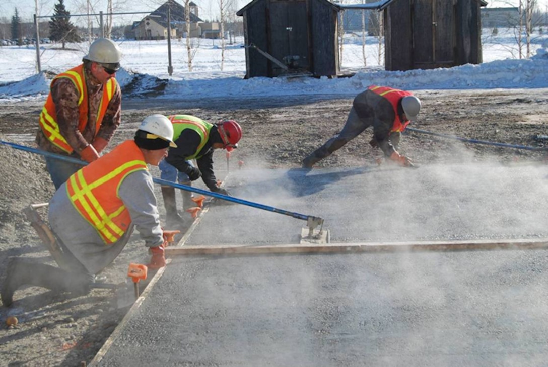 Contractors finish the surface of a concrete slab constructed with antifreeze concrete during a field demonstration at Fort Wainwright, Alaska, in March 2015. The air temperature was 14oF (−10oC).