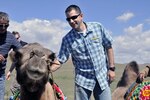 Capt. Chad Ausel, a member of the 761st Military Police Battalion of the Alaska Army National Guard, pets a camel to get more comfortable before taking a ride on its back during a Morale, Welfare and Recreation day in Ulaanbaatar, Mongolia, Aug. 15, 2010.