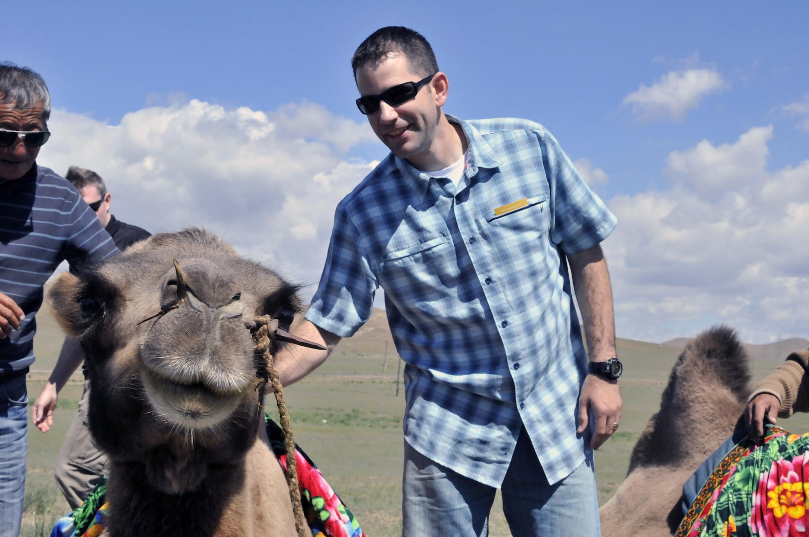 Capt. Chad Ausel, a member of the 761st Military Police Battalion of the Alaska Army National Guard, pets a camel to get more comfortable before taking a ride on its back during a Morale, Welfare and Recreation day in Ulaanbaatar, Mongolia, Aug. 15, 2010.