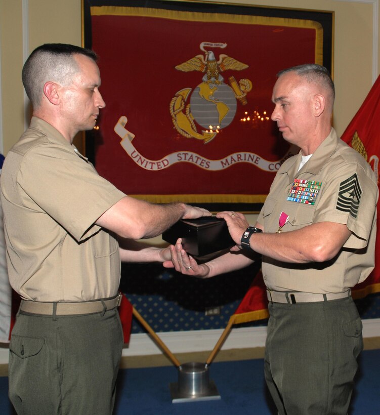 Sgt. Maj. Kevin Conboy (right), sergeant major, Headquarters Group, Marine Corps Logistics Command, receives the American flag from Lt. Col. Adrian Cleymans, executive officer, Marine Depot Maintenance Command, and retiring official, during his retirement ceremony, April 9. The ceremony was held at Marine Corps Logistics Base Albany's Major S. P. “Swede” Hansen Officers’ Lounge.