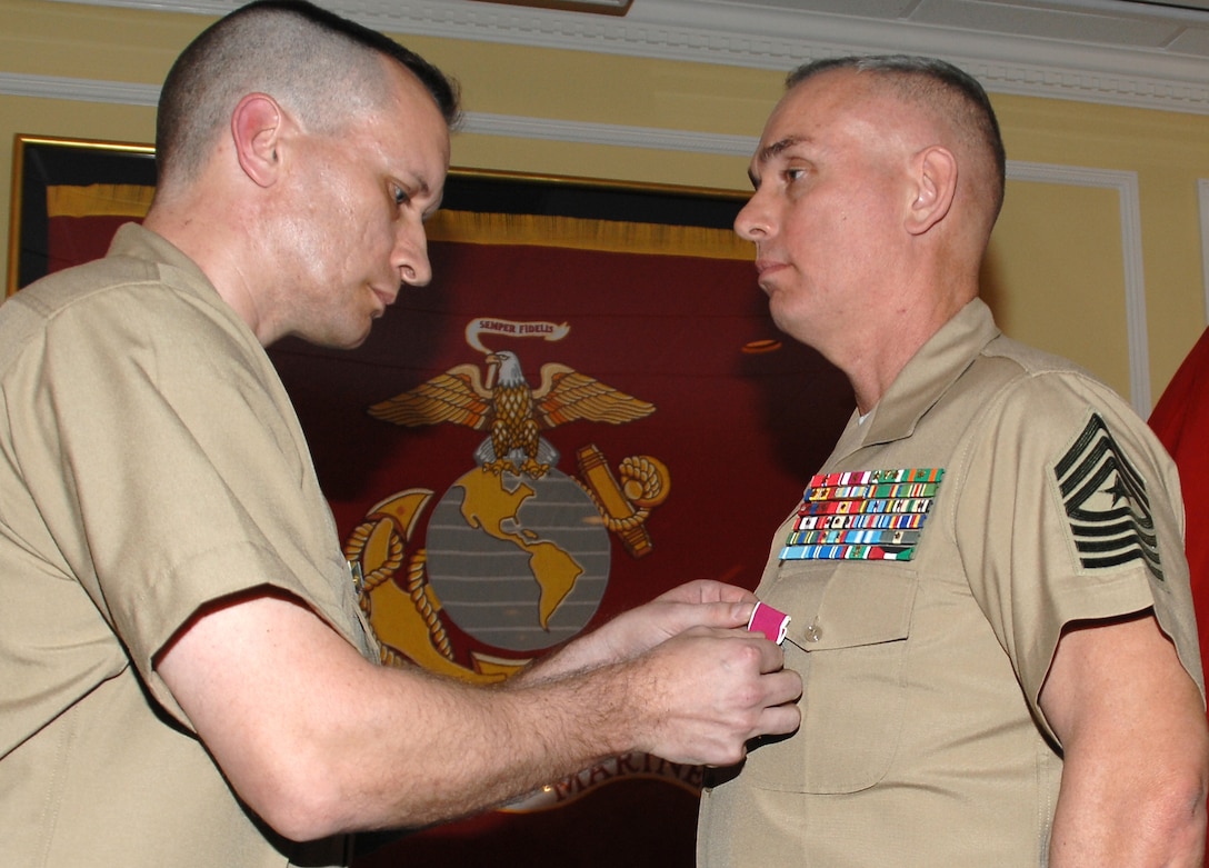 Sgt. Maj. Kevin Conboy (right), sergeant major, Headquarters Group, Marine Corps Logistics Command, receives the Legion of Merit from Lt. Col. Adrian Cleymans, executive officer, Marine Depot Maintenance Command, and retiring official, during his retirement ceremony, April 9. The ceremony was held at Marine Corps Logistics Base Albany's Major S. P. “Swede” Hansen Officers’ Lounge.