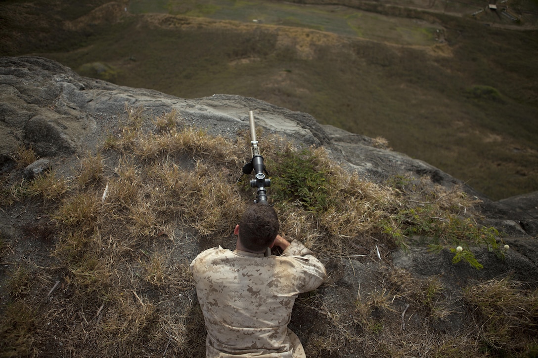 Lance Cpl. Patrick Casey, a Rifleman assigned to sniper platoon, 2nd Battalion, 3rd Marine Regiment, observes his target at Range 10 aboard Marine Corps Base Hawaii, April 8, 2015. Lance Cpl. Casey is improving his efficiency in sniper training prior to being sent to Scout Sniper Basic Course at Camp Pendleton, California.