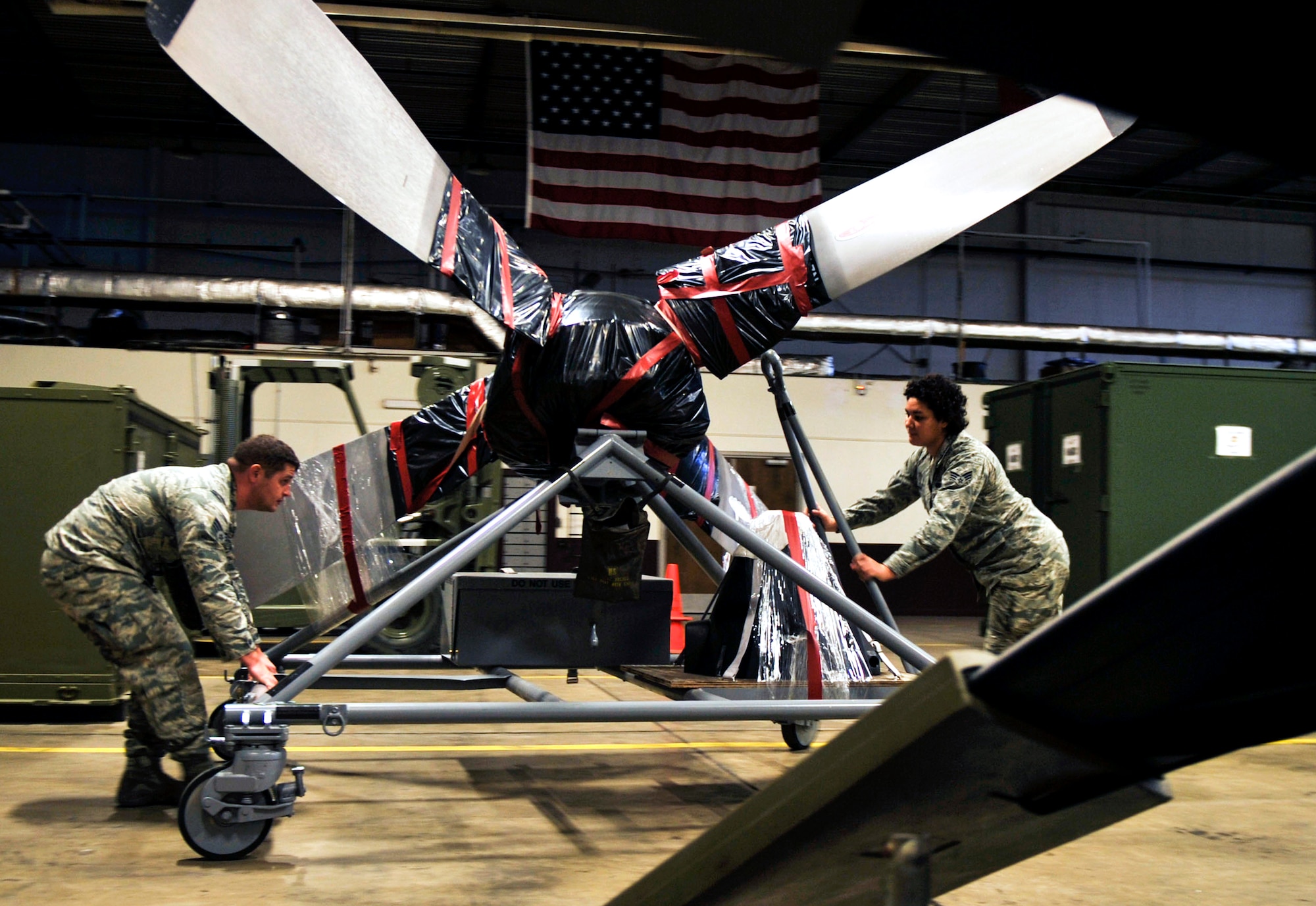 Senior Airman Nathan Pile, a 19th Logistics Readiness Squadron mobility readiness spares packages journeyman, and Senior Airman Shantwanique Harris, a 19th Logistics Readiness Squadron mobility readiness spares packages journeyman, move a propeller March 12, 2015, at Little Rock Air Force Base, Ark. A single propeller costs approximately $600,000.  (U.S. Air Force photo by Senior Airman Stephanie Serrano) 