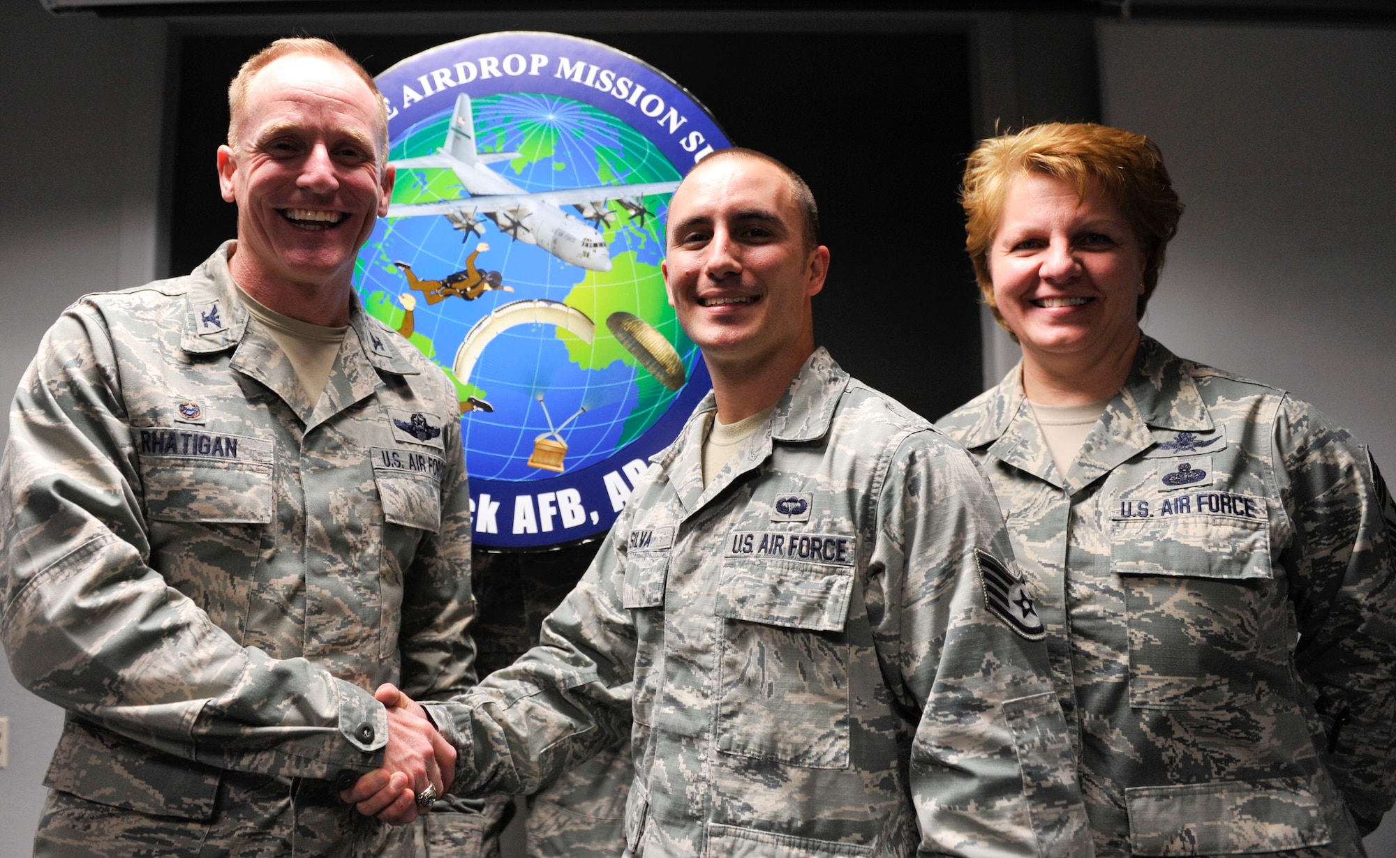 Col. Patrick Rhatigan, 19th Airlift Wing commander, along with Chief Master Sgt. Rhonda Buening, 19th AW command chief, congratulate Staff Sgt. Joshua Silva, the 19th Aerospace Medical Squadron noncommissioned officer-in-charge of High Altitude Airdrop Mission Support equipment, March 30, 2015, at Little Rock Air Force Base, Ark. Silva, a Lodi, Calif., native, reviewed and edited 50 adjudicated questions on AFI 11-409 facilitating a quick response to higher headquarters. (U.S. Air Force photo by Senior Airman Regina Edwards)