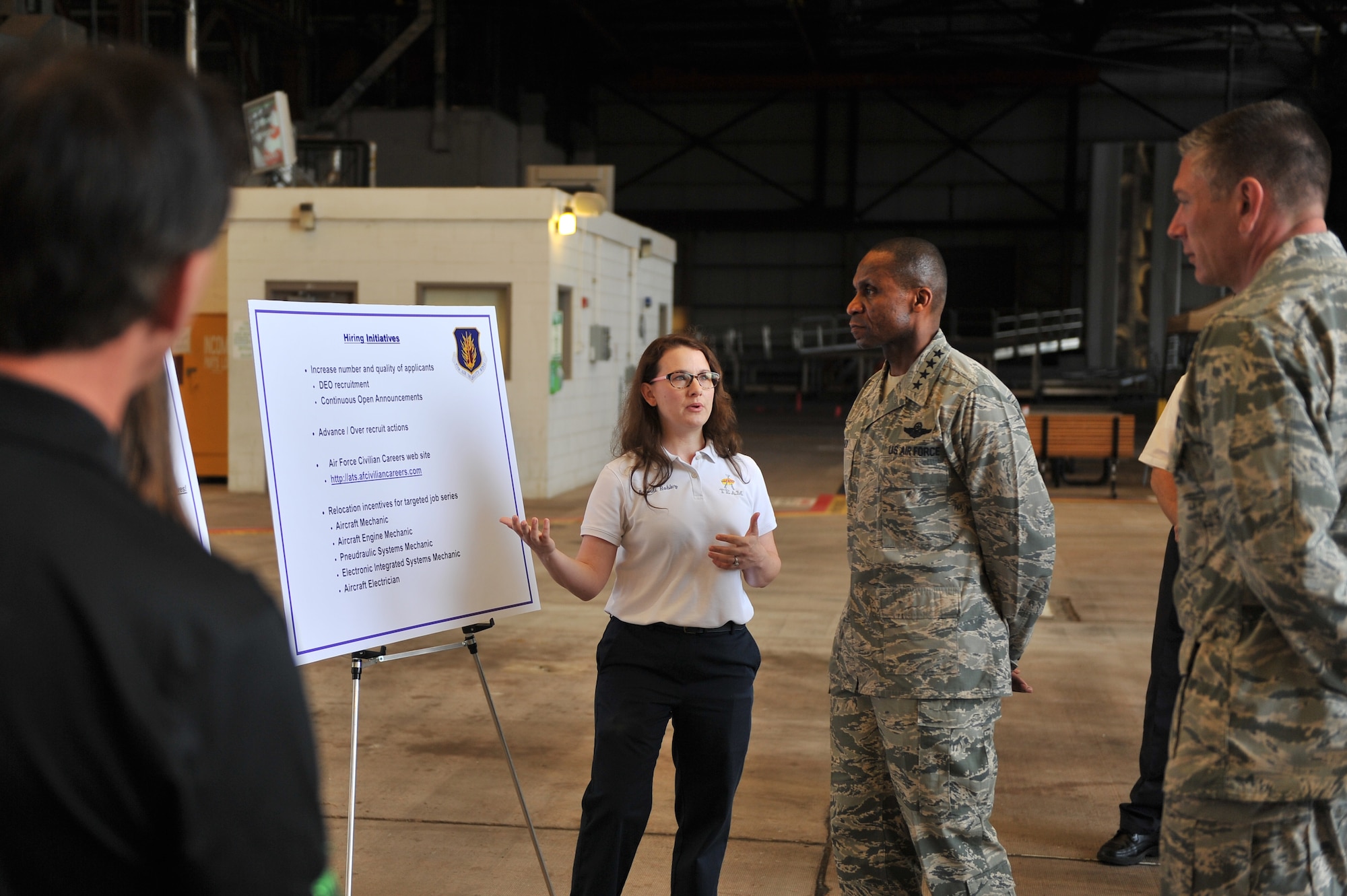 ALTUS AIR FORCE BASE, Okla. – Brandi Roblez, 97th Maintenance Directorate A-Team member, briefs U.S. Air Force Gen. Darren McDew, Air Mobility Command commander, on the Altus AFB “Grow Your Own Mechanic” program, April 8, 2015. Roblez explained to McDew how the program teaches and certifies people from the local community to work and excel in aircraft maintenance. (U.S. Air Force photo by Senior Airman Dillon Davis/Released)