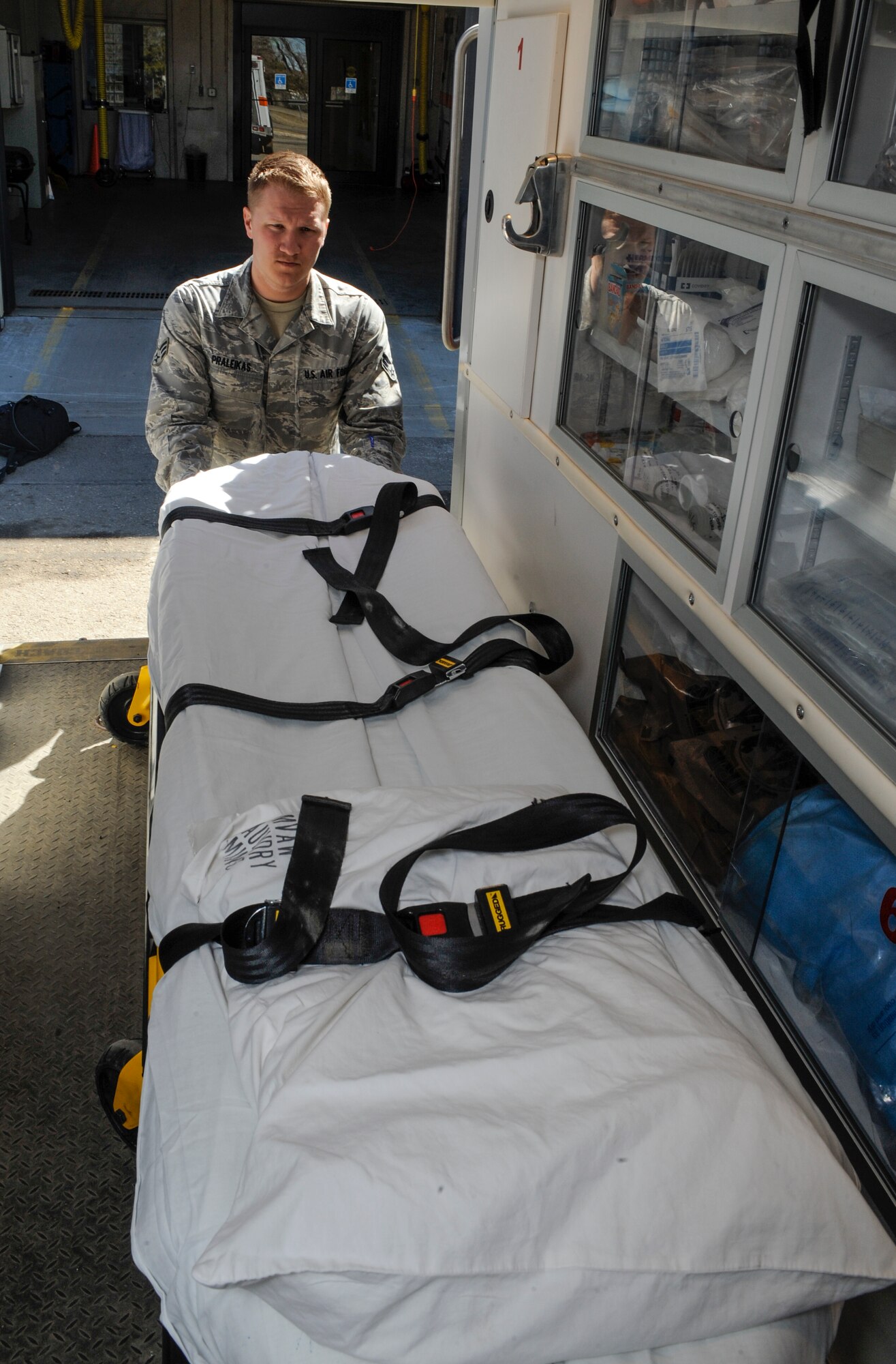 Senior Airman Ryan Praleikas, 5th Medical Operations Squadron emergency medical technician, loads a gurney into an ambulance on Minot Air Force Base, N.D., March 30, 2015. In addition to gurneys and ambulances, personnel in Praleikas’ section are trained to work with LIFEPAK15 cardiac monitors, stairchairs, backboards and a host of other emergency medical equipment. (U.S. Air Force photo/Senior Airman Stephanie Morris)
