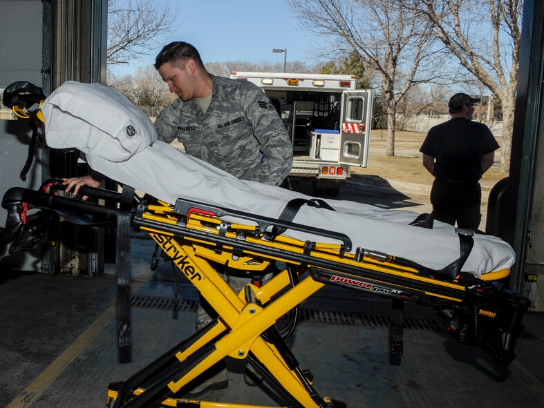Senior Airman Ryan Praleikas, 5th Medical Operations Squadron emergency medical technician, wheels a gurney into the 5th Medical Group building on Minot Air Force Base, N.D., March 30, 2015. In addition to gurneys and ambulances, personnel in Praleikas’ section are trained to work with LIFEPAK15 cardiac monitors, stairchairs, backboards and a host of other emergency medical equipment. (U.S. Air Force photo/Senior Airman Stephanie Morris)