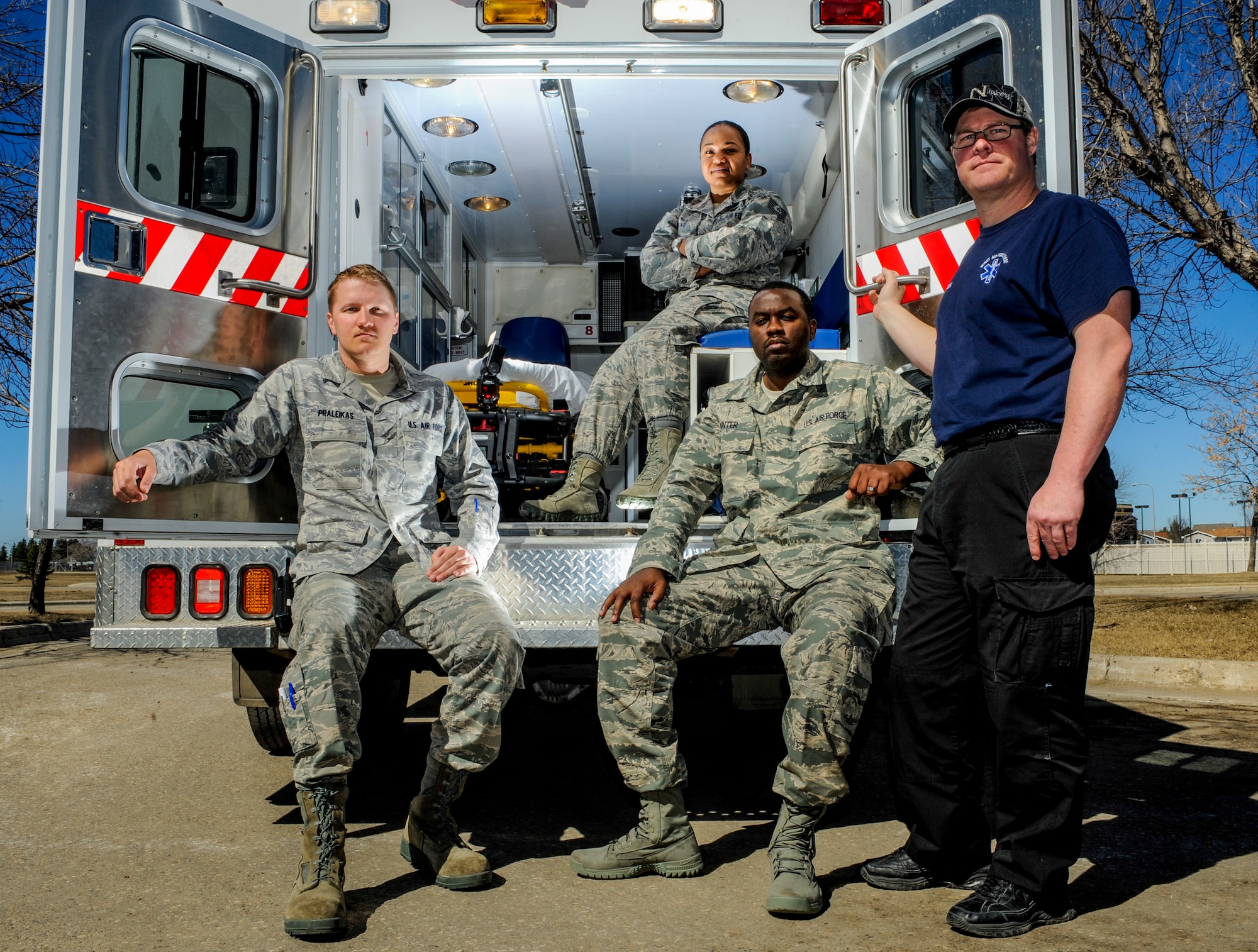 (From left to right) Senior Airman Ryan Praleikas, 5th Medical Operations Squadron emergency medical technician, Tech. Sgt. Jesseka King, 5th MDOS NCO in charge of ambulance services, Airman 1st Class Karlton Minter, 5th MDOS EMT, and Cary Kehr, 5th MDOS paramedic, pose for a photograph on Minot Air Force Base, N.D., March 30, 2015. Ambulance services personnel are on call 24/7, 365 days a year ready to respond to calls for medical aid and transport their patients quickly and safely downtown if needed. (U.S. Air Force photo/Senior Airman Stephanie Morris)
