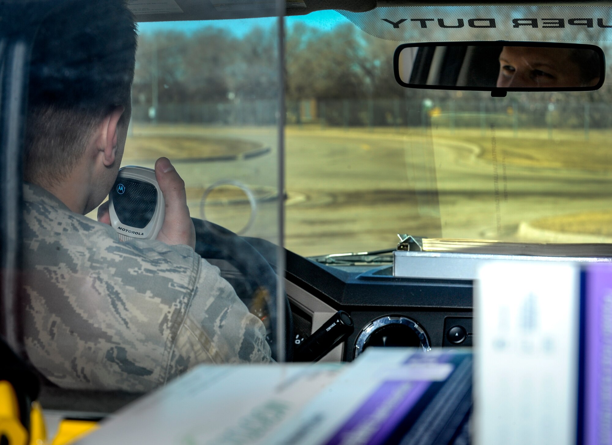 Senior Airman Ryan Praleikas, 5th Medical Operations Squadron emergency medical technician, talks over an ambulance radio during a simulated response on Minot Air Force Base, N.D., March 30, 2015. Praleikas and other emergency medical technicians in his section work 12 hour panama shifts, two days on and two to three days off. (U.S. Air Force photo/Senior Airman Stephanie Morris)