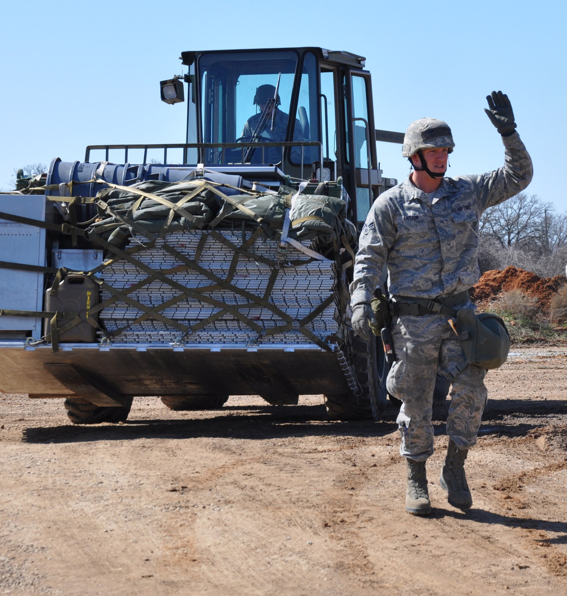 Senior Airman Ryan LaFleur, 301st Logistics Readiness Squadron, guides the forklift driver, Staff Sgt. Dimitri Morton, March 6, 2015 during an exercise at Fort Wolters, Texas. Within 24 hours, nearly 140 Airmen from seven offices throughout the 301st Fighter Wing traveled through a personnel-processing line and then carried out their duty-specific tasks in a simulated deployed environment.  (Air Force photo/Capt. Candice Allen)