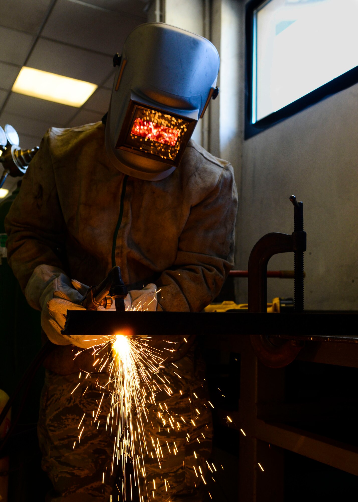 U.S. Air Force Staff Sgt. Fabrizzio Morocho, 31st Civil Engineer Squadron structural craftsman, cuts a metal T-bar segment April 7, 2015, at Aviano Air Base, Italy. Structures Airmen perform many tasks with different materials and tools to “build” the Air Force mission. (U.S. Air Force photo by Senior Airman Austin Harvill/Released)