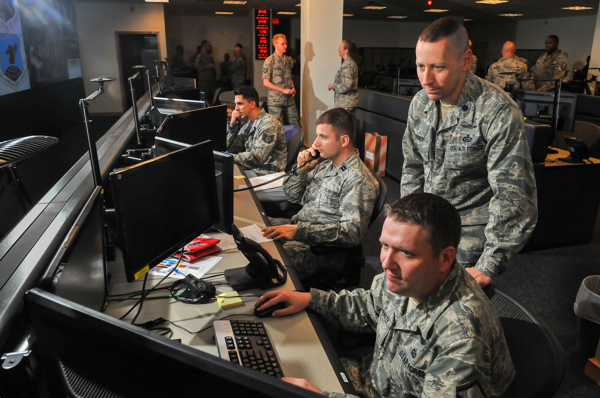 Following the construction of the 25th Air Force Operations Center, OC members (seated left to right) Tech. Sgt. Juan Pastrana, Capt. William Carpenter and Master Sgt. Wesley Daugherity man positions March 25 under the supervision of Lt. Col. Paul Risner, senior duty officer.(U. S. Air Force photo by William Belcher)  
