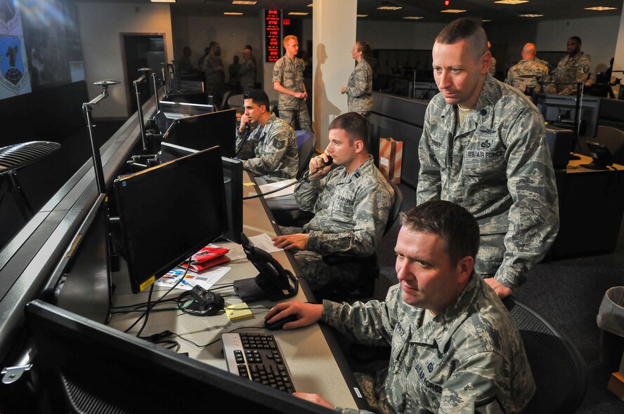 Following the construction of the 25th Air Force Operations Center, OC members (seated left to right) Tech. Sgt. Juan Pastrana, Capt. William Carpenter and Master Sgt. Wesley Daugherity man positions March 25 under the supervision of Lt. Col. Paul Risner, senior duty officer.(U. S. Air Force photo by William Belcher)  
